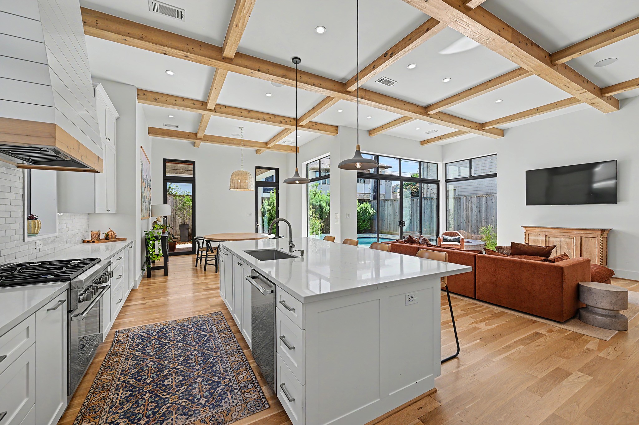 The beautifully appointed kitchen features quartz countertops, a custom range hood and generous workspace.