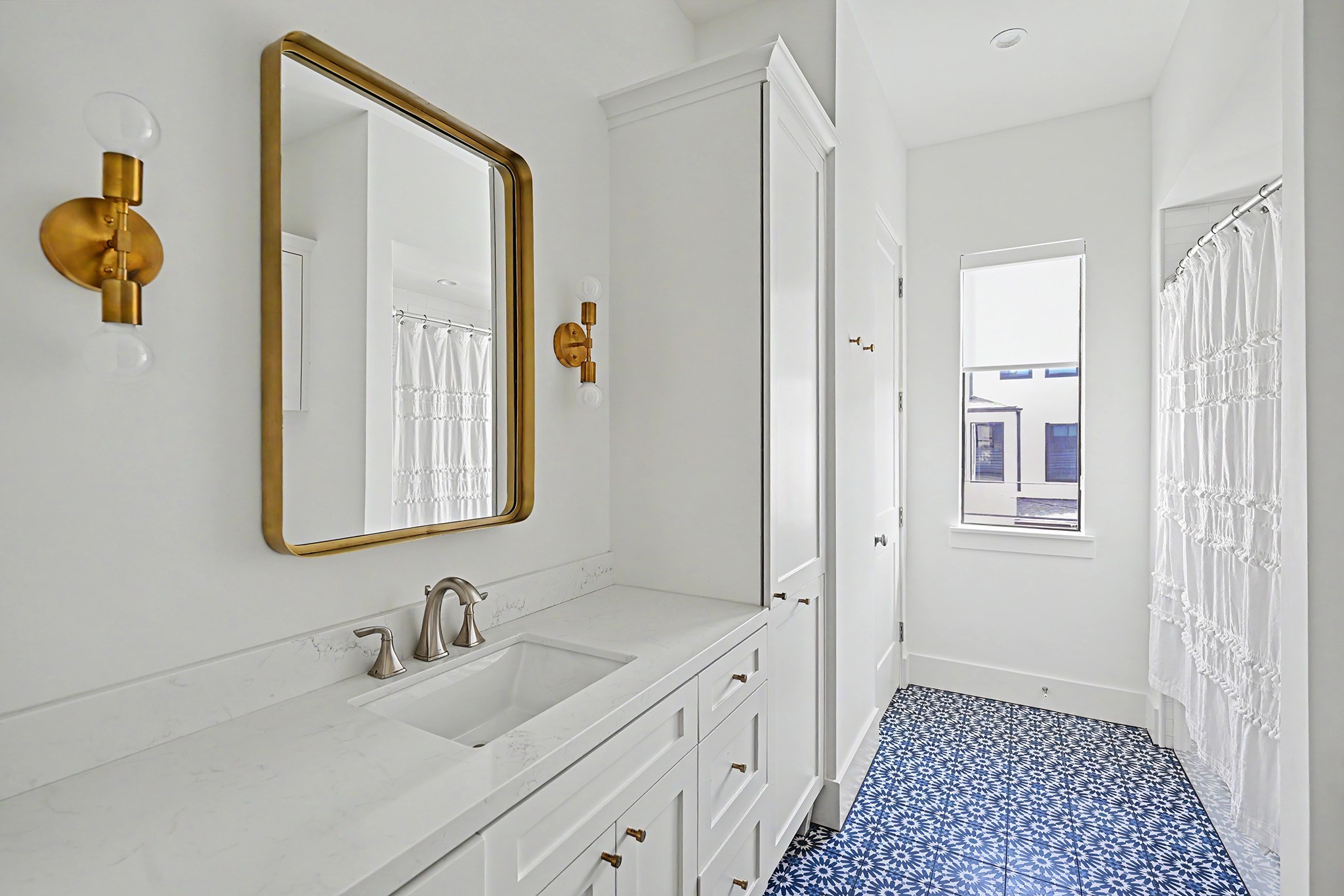 Full secondary bathroom features elegant brass accents and thoughtfully selected tilework.