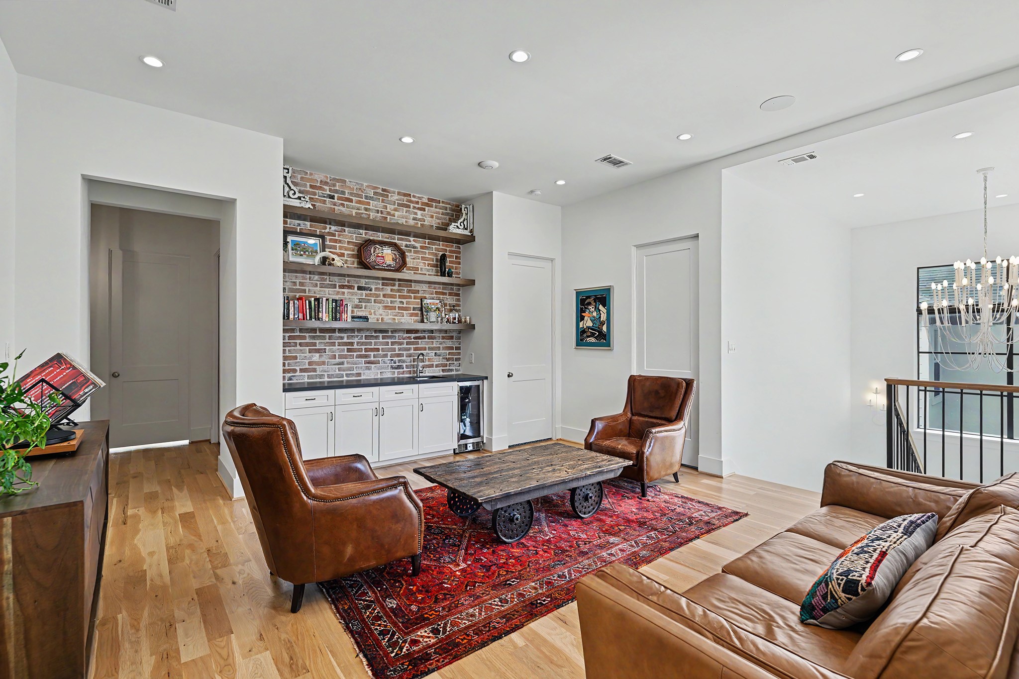 A second view of the game room highlights custom built-ins, antique like hardware and a handsome brick accent.