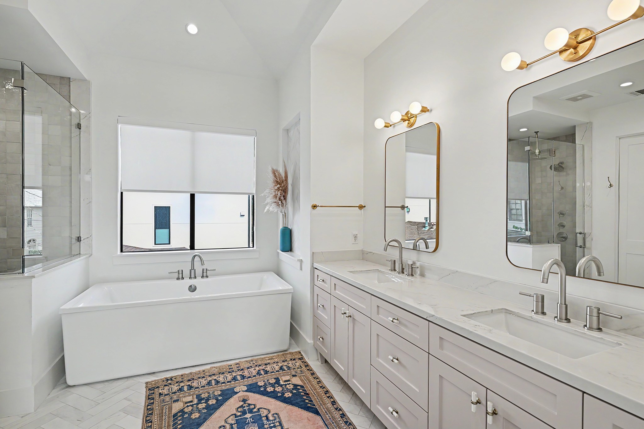 The primary bath features a freestanding soaking tub, dual vanities and a sophisticated combination of marble and Riad tile.
