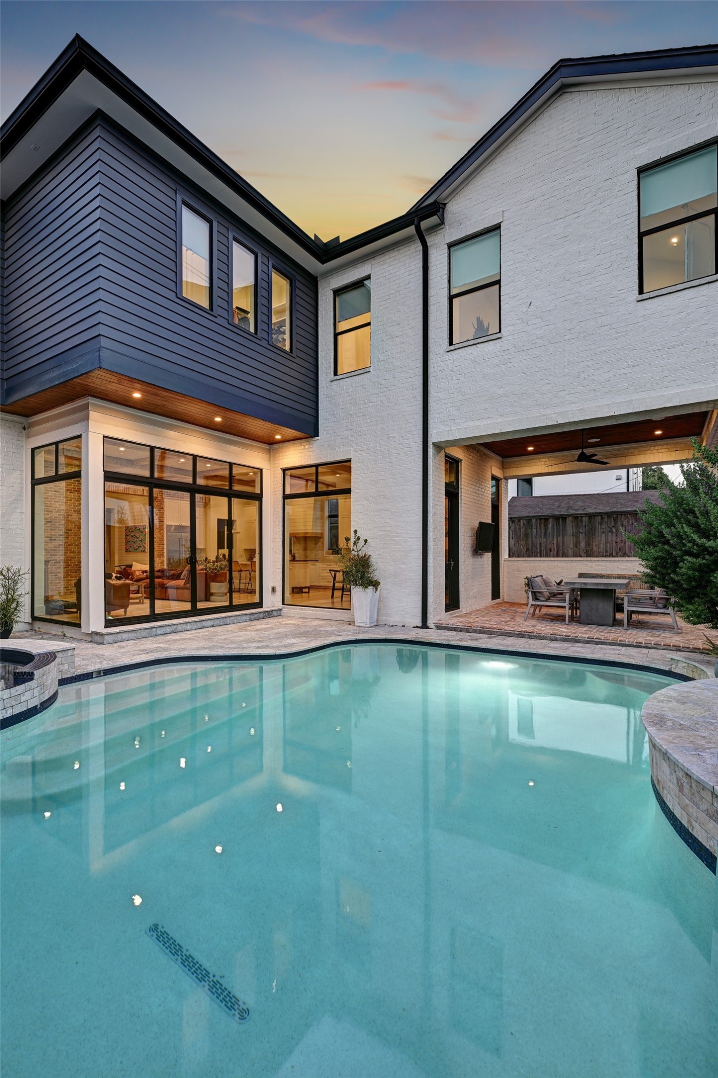 Expansive windows and doors provide a striking connection between the pool and the homes light-filled interior.
