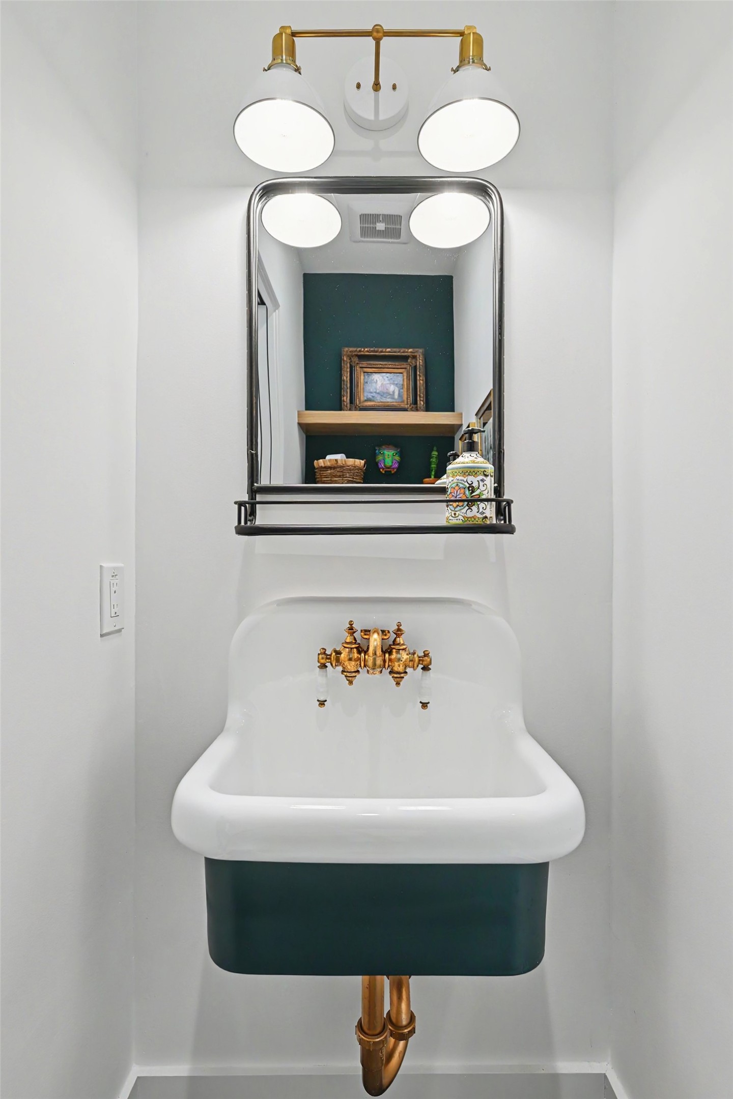 The powder room makes a memorable statement with basalt limestone, a vintage-inspired porcelain sink and curated lighting.