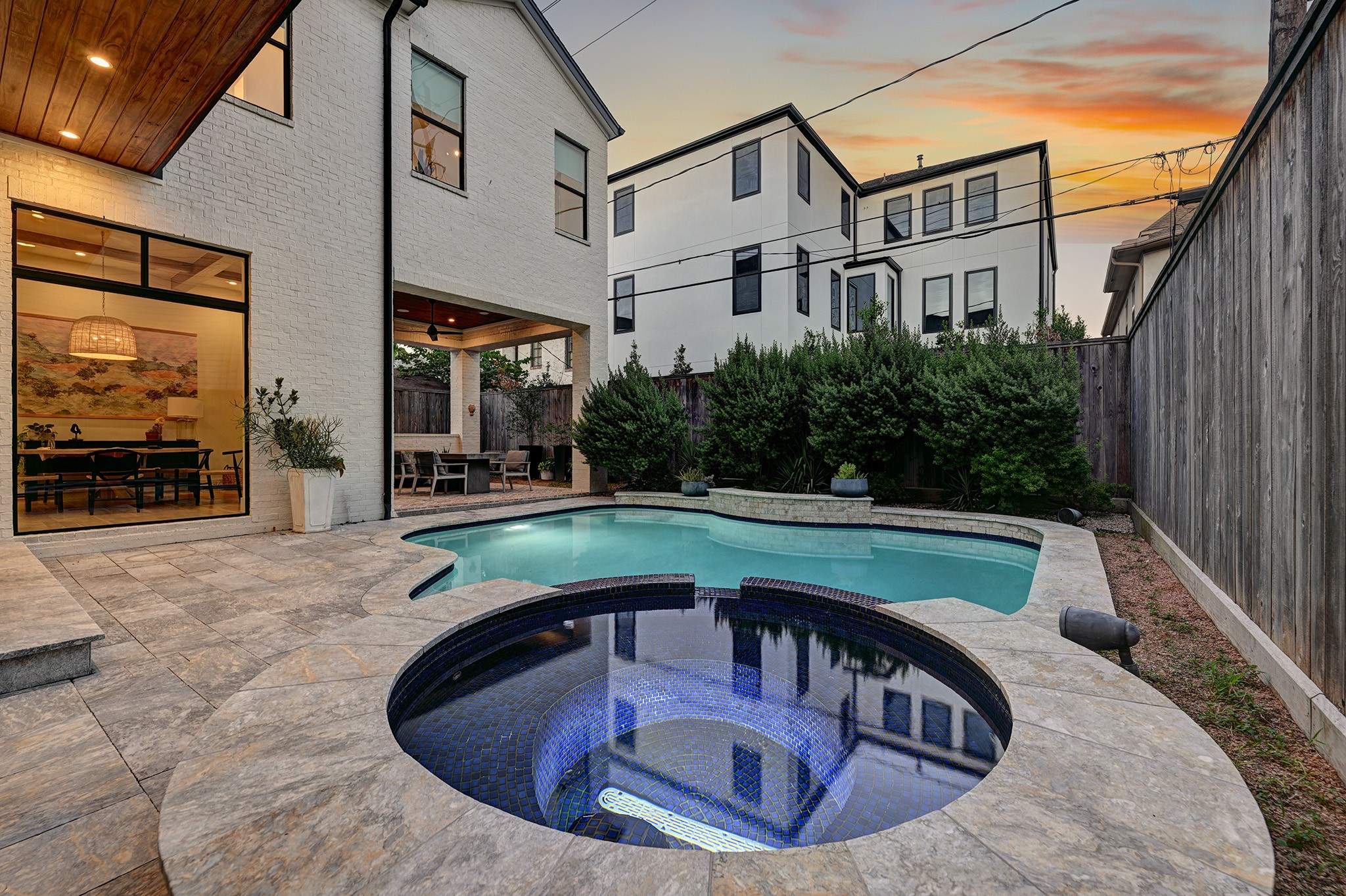 An evening view captures the pool, spa and beautifully designed backyard entertaining space.