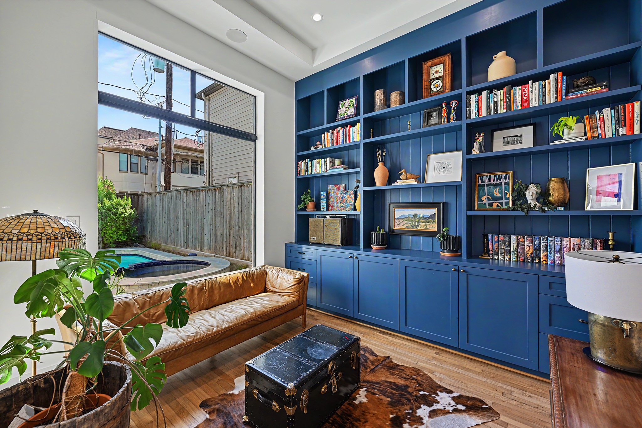 The study pairs preserved hardwood from the original 1920 home with custom blue built-ins and antique hardware.