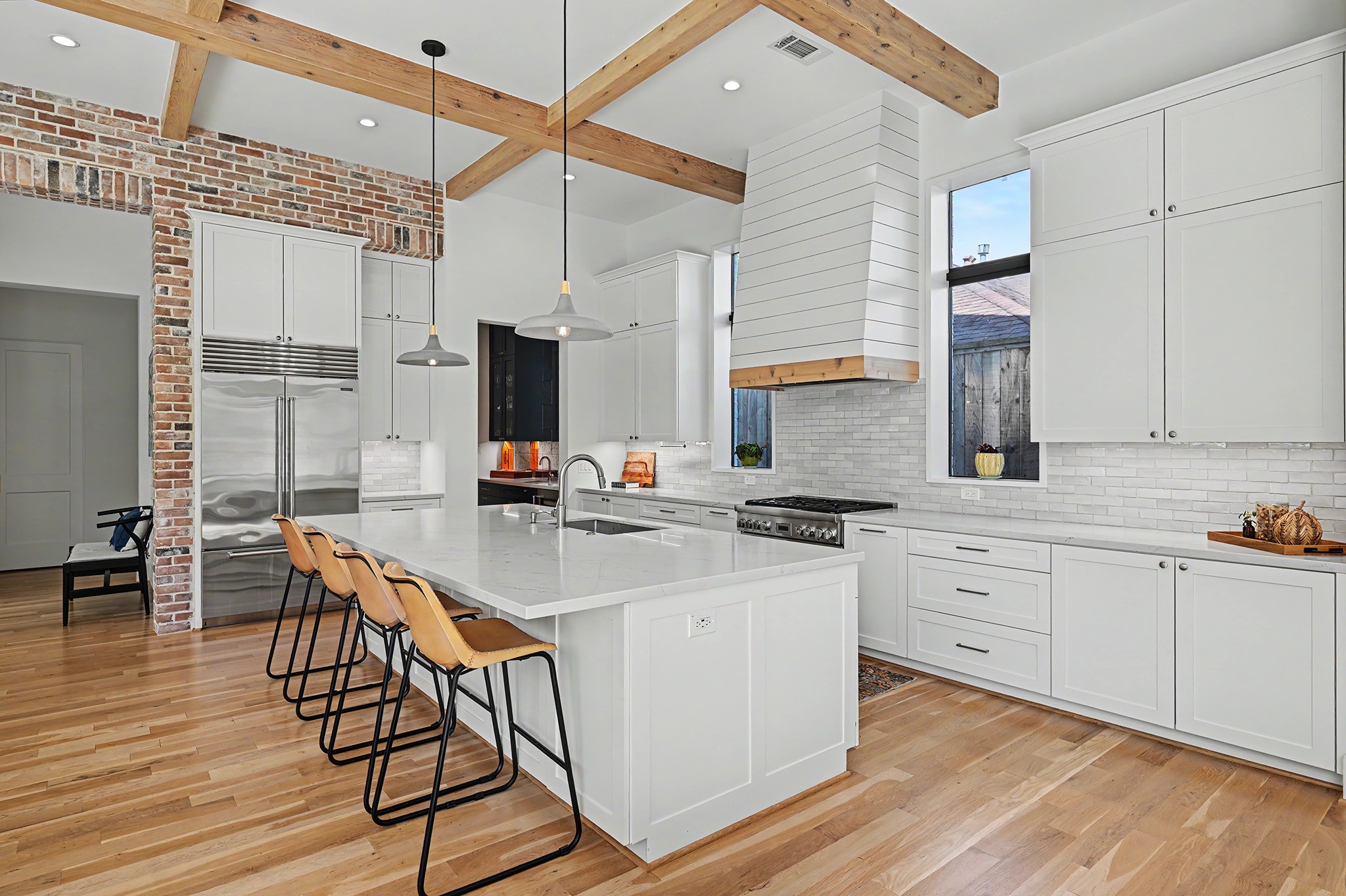 Custom cabinetry, quartz surfaces and refined finishes give the kitchen a clean, timeless character.