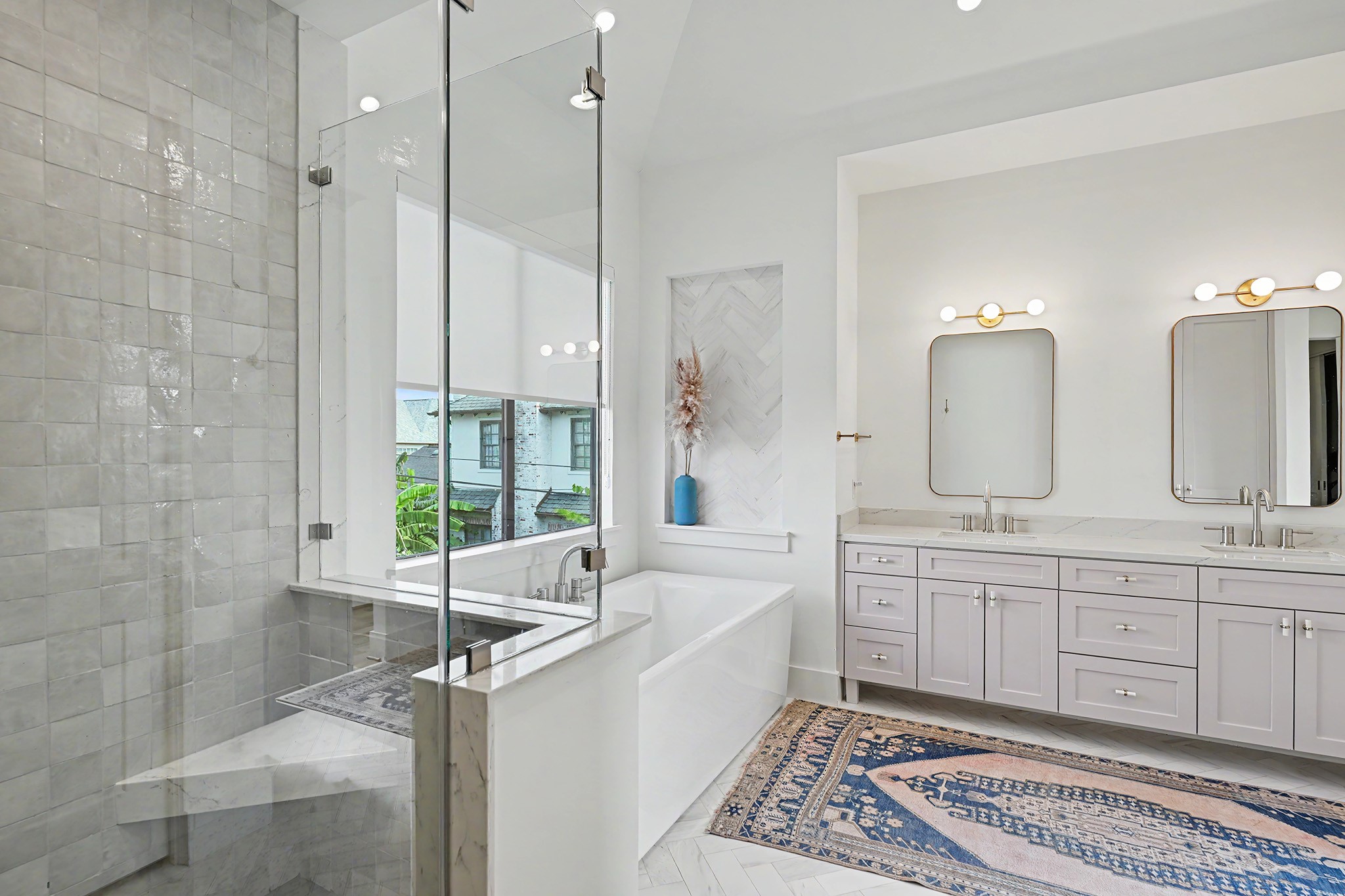 The glass-enclosed primary shower showcases beautifully selected Riad tile and a spacious, tailored design.