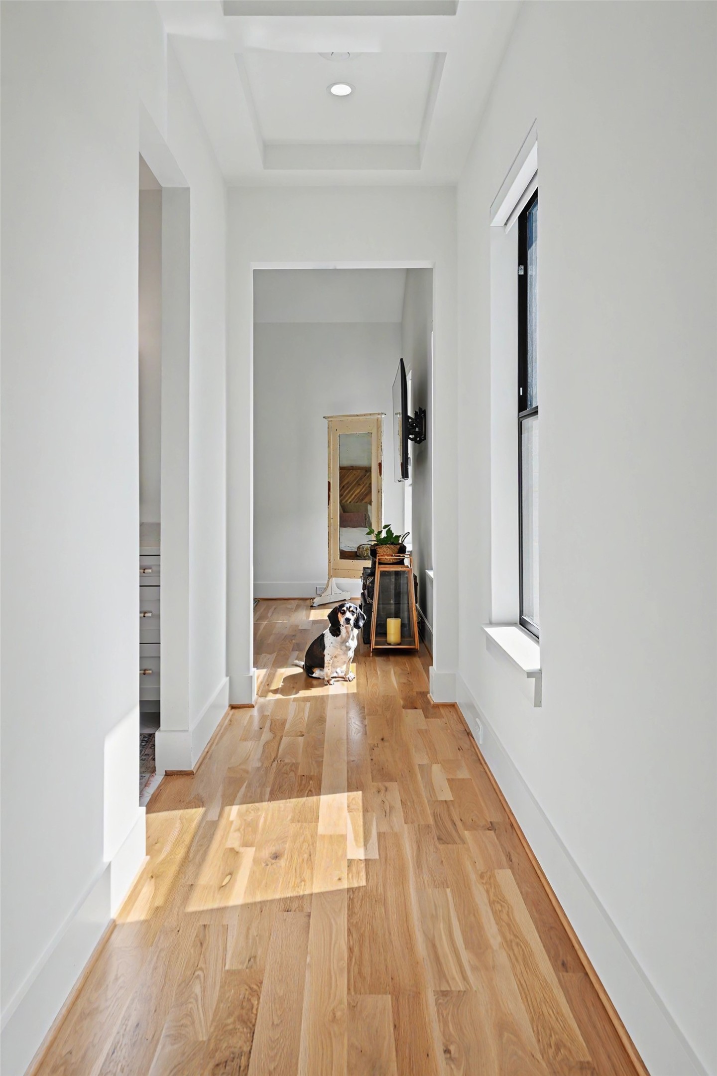 The light-filled upstairs hallway headed into your primary suite continues the homes white oak flooring and clean architectural lines.
