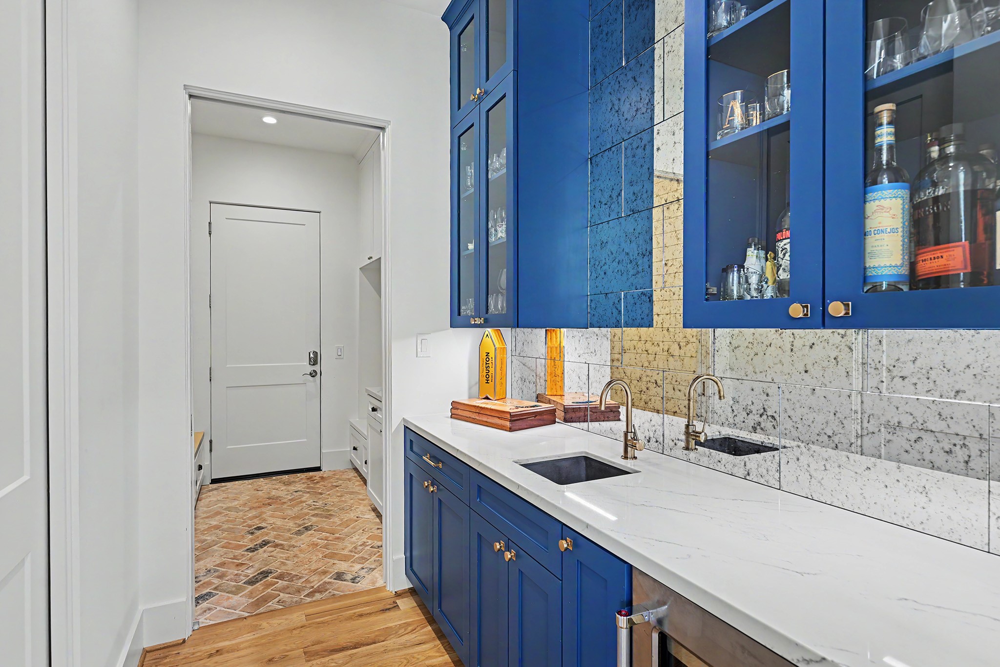 Rich blue cabinetry brings depth and personality to the butlers pantry and wet bar.