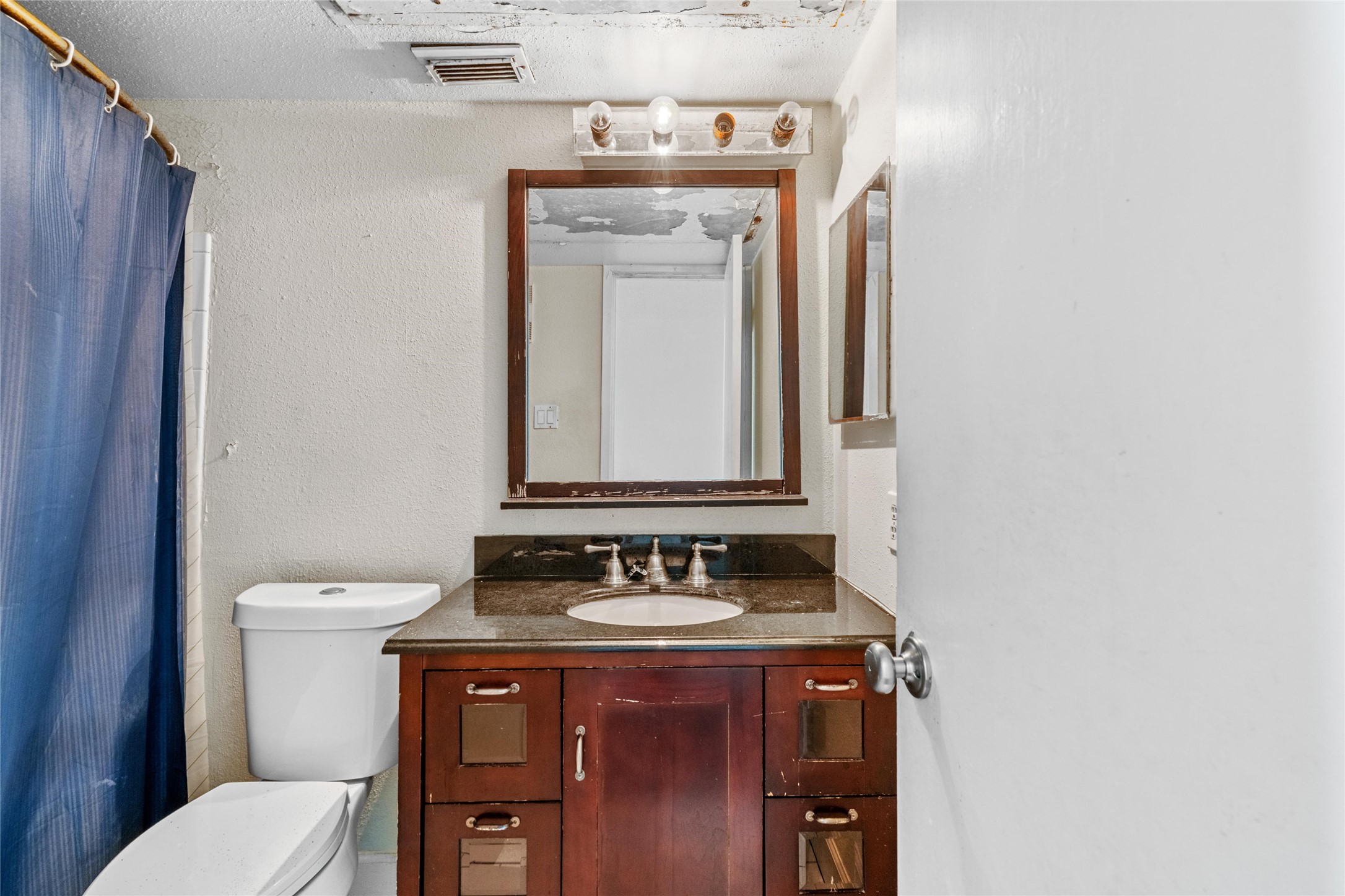 Full bathroom features a vanity area with mirror and practical layout for everyday use.