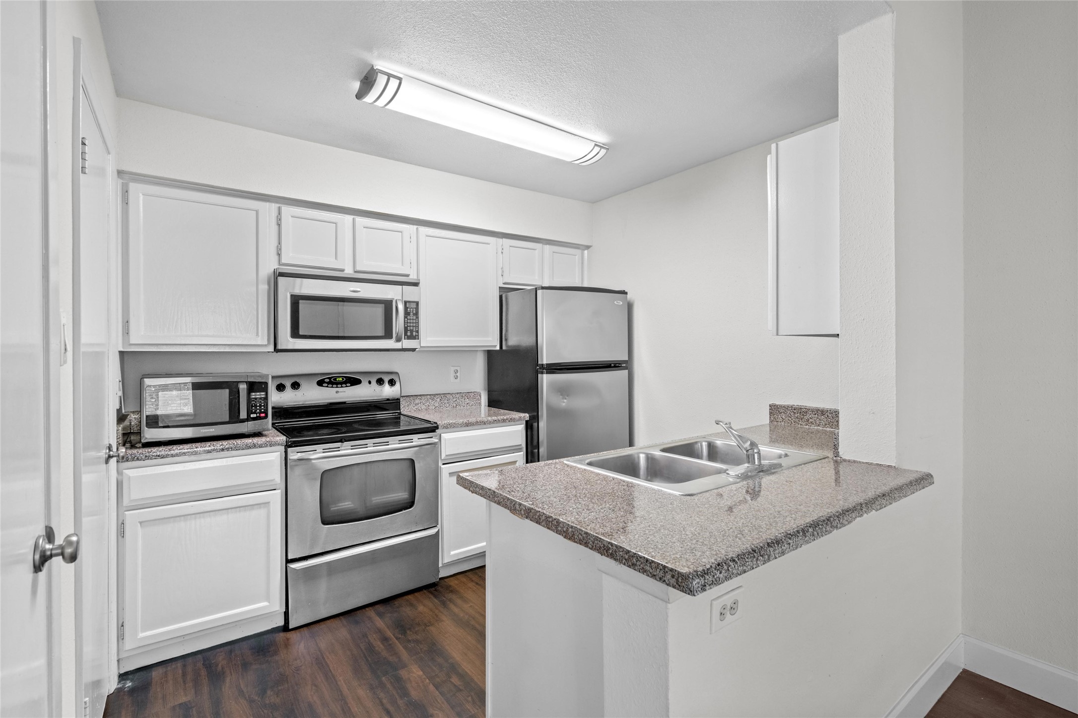 Functional kitchen features white cabinetry, stainless-steel appliances, and generous counter space for everyday meal preparation. Functional kitchen features white cabinetry, stainless-steel appliances, and generous counter space for everyday meal preparation.