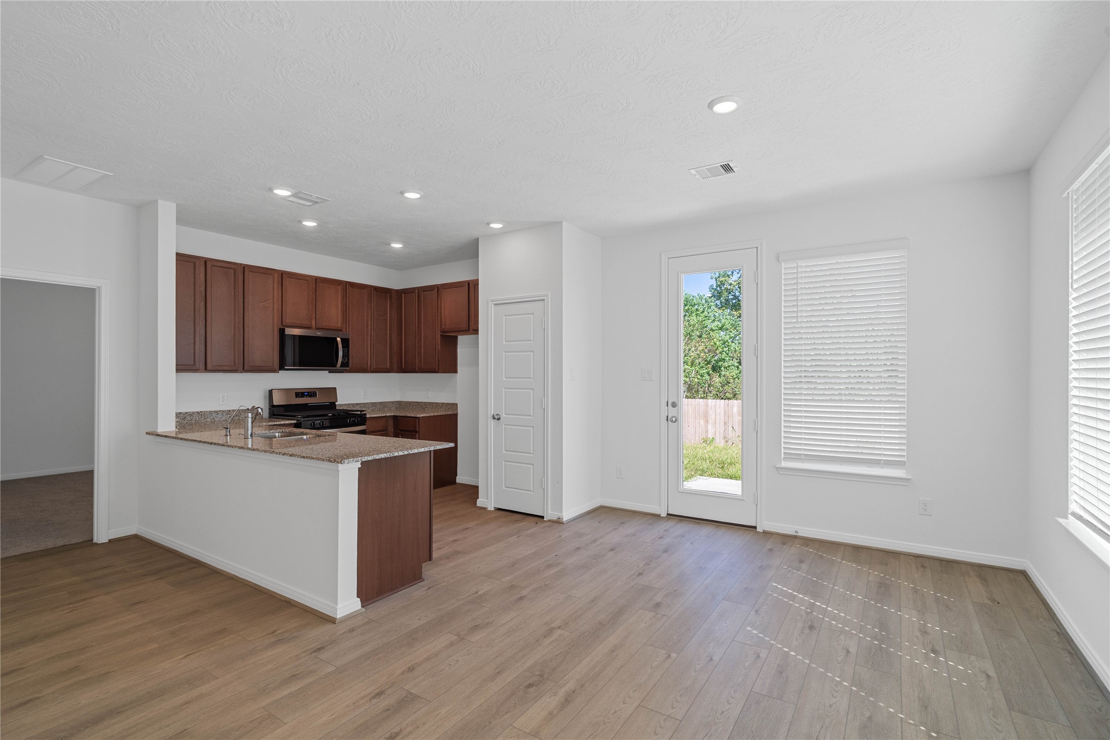 Sun-drenched dining space flows effortlessly into a modern kitchen, creating the ultimate hub for daily living.