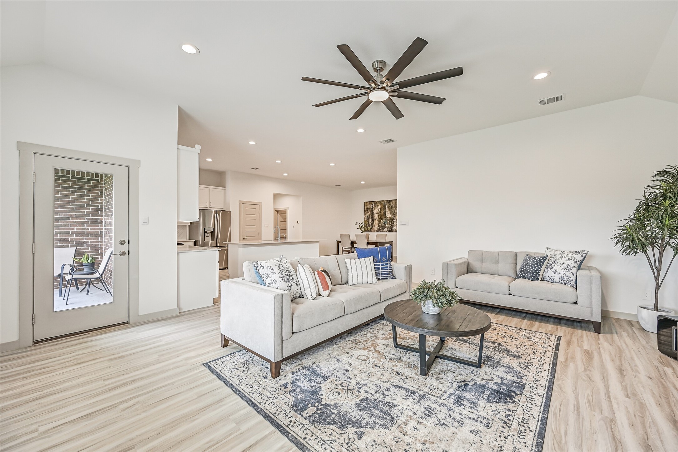 The generously sized family room opens directly to the kitchen and dining areas and features wood-look flooring, recessed lighting, a contemporary oversized ceiling fan and a full-glass door leading to the covered patio.
