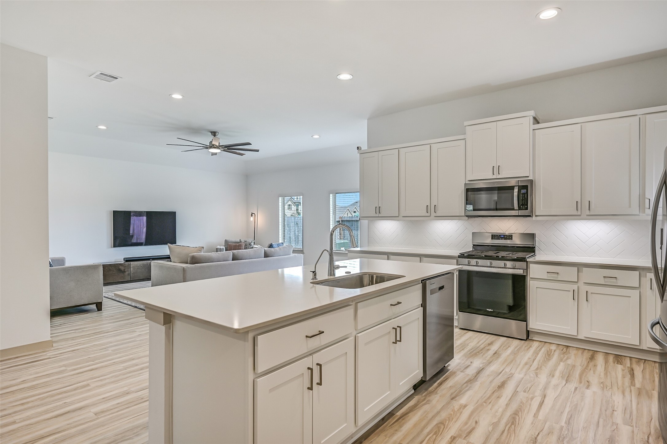 The oversized island anchors the kitchen with generous workspace, an undermount sink, dishwasher and additional cabinetry, while the open design keeps the cook connected to the adjoining family room.