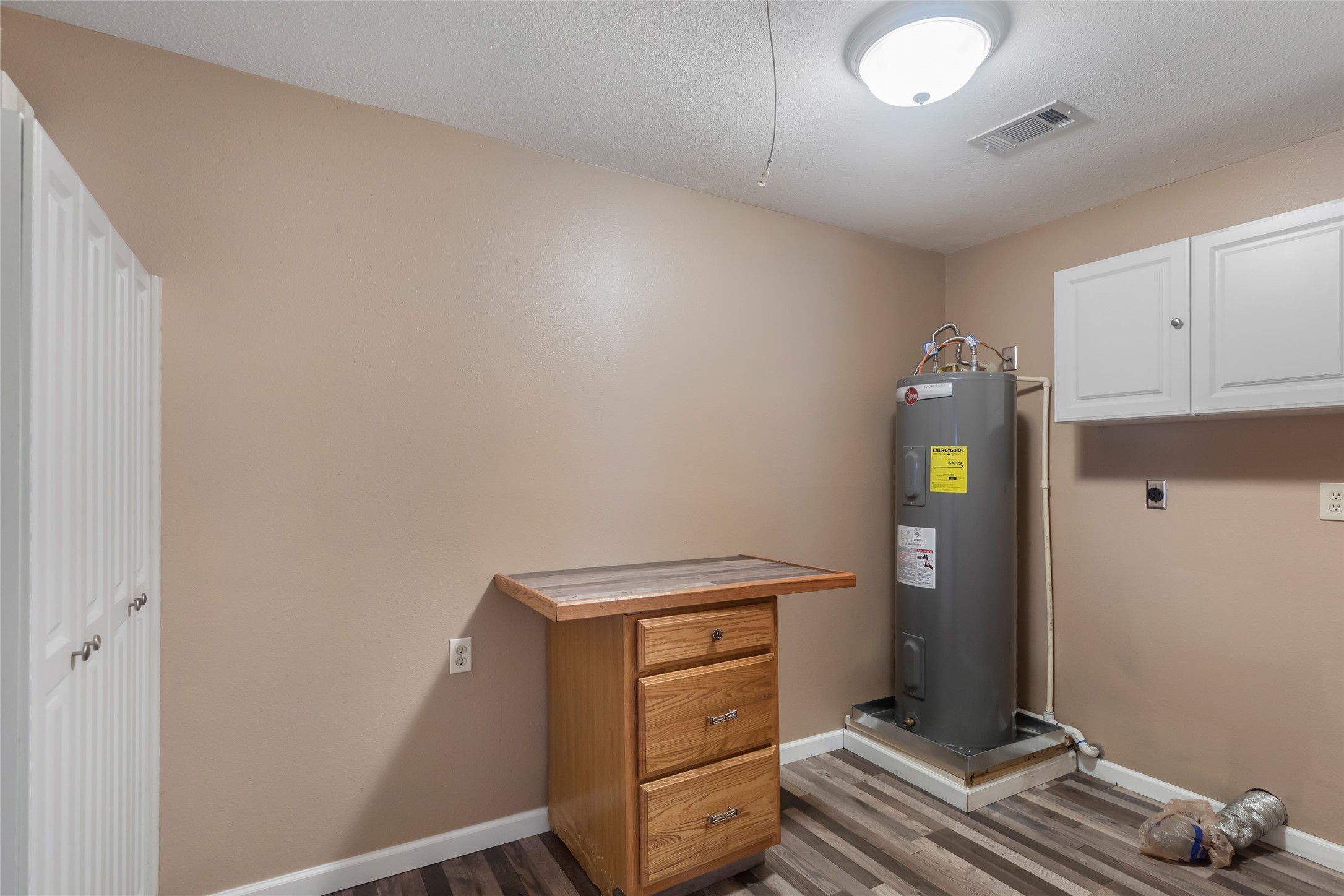 Dedicated utility space with water heater and additional storage potential.