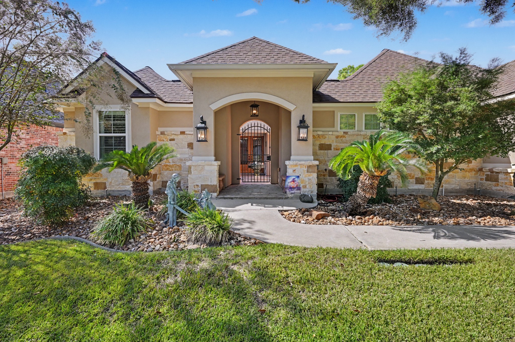 Elegant front elevation featuring a welcoming arched entry and beautiful stone accents.