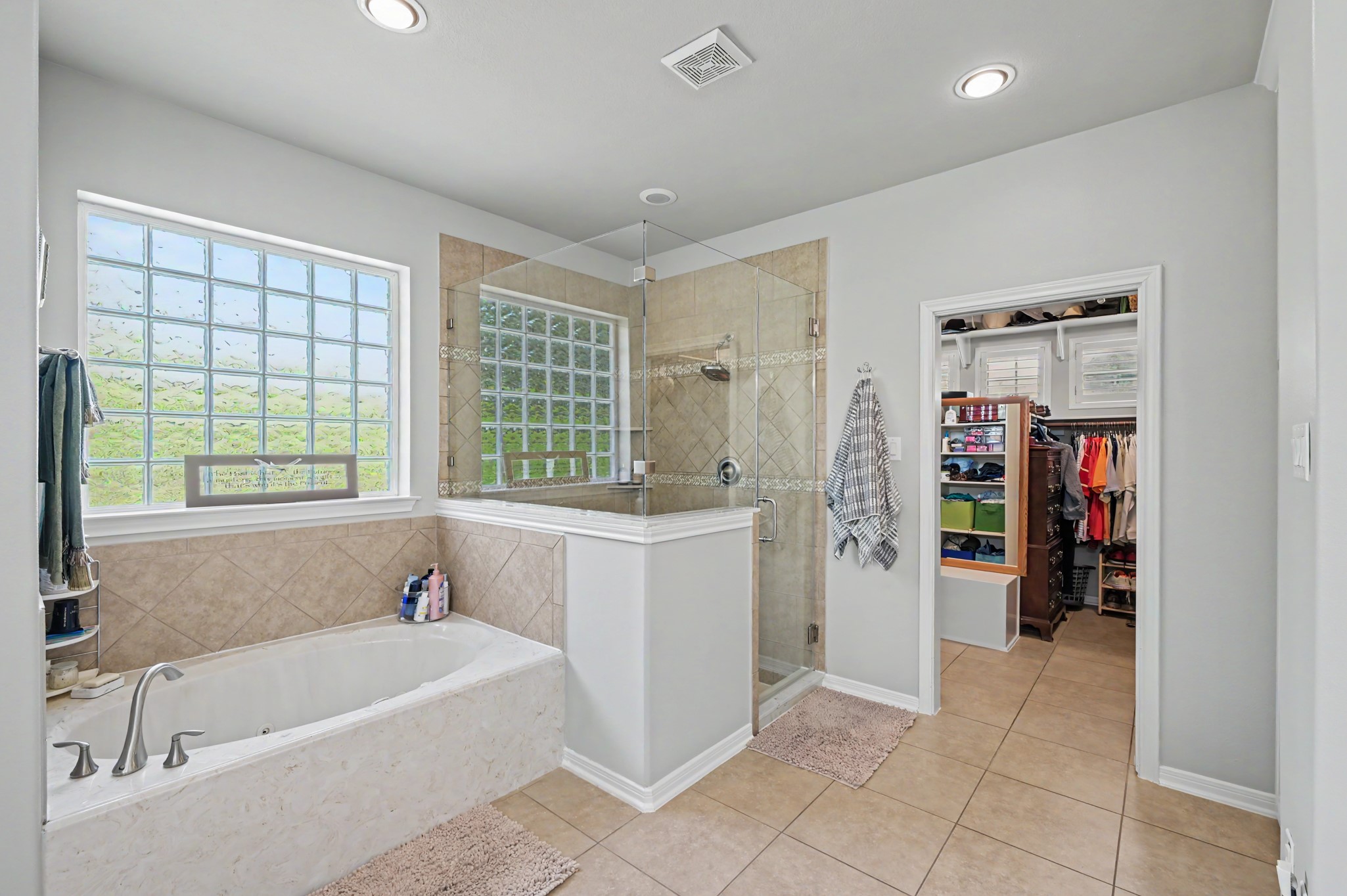 Relaxing primary bath featuring a jetted soaking tub, separate shower, and natural light.