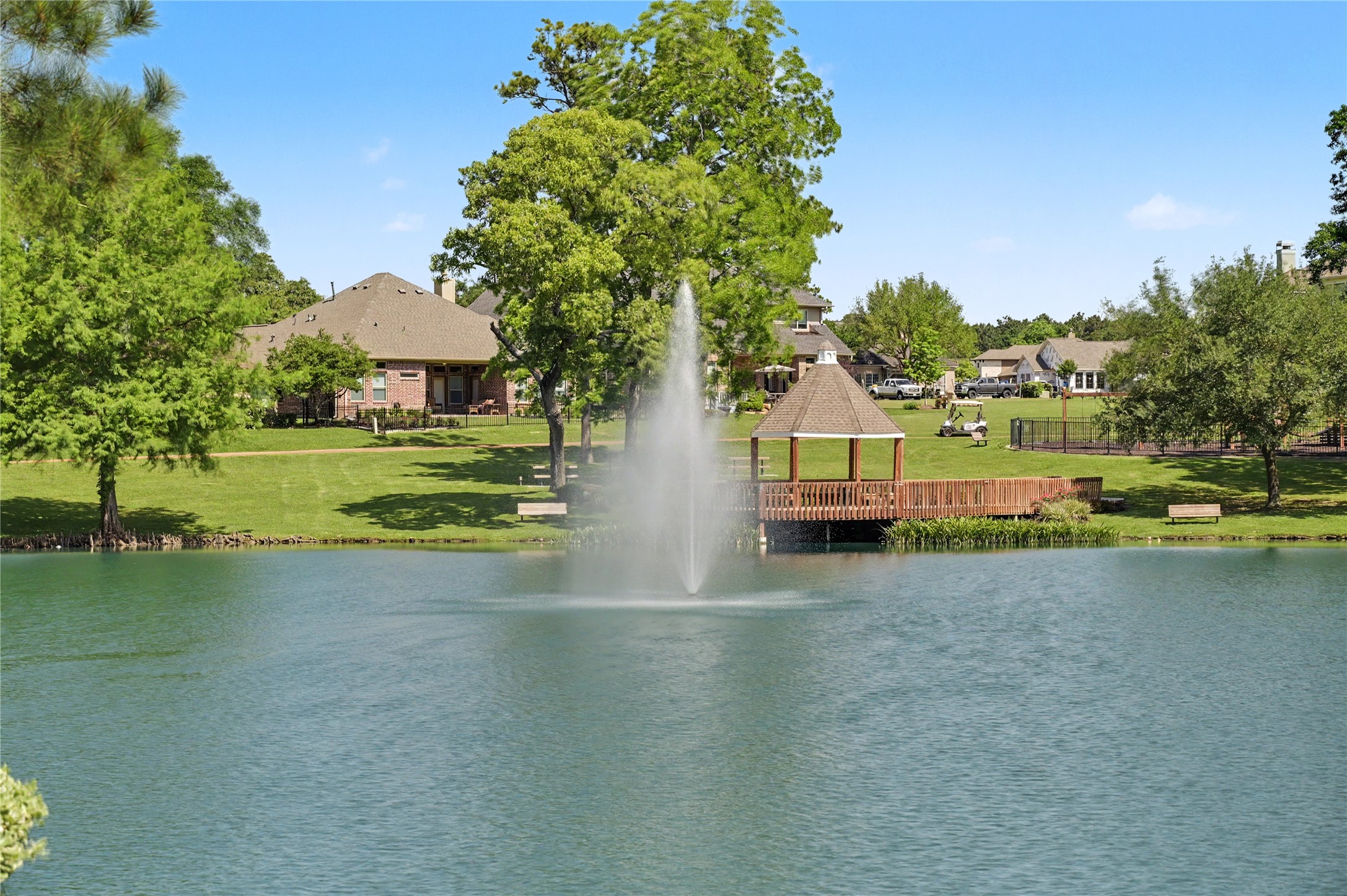 Serene pond with a graceful fountain and lush surrounding landscape.