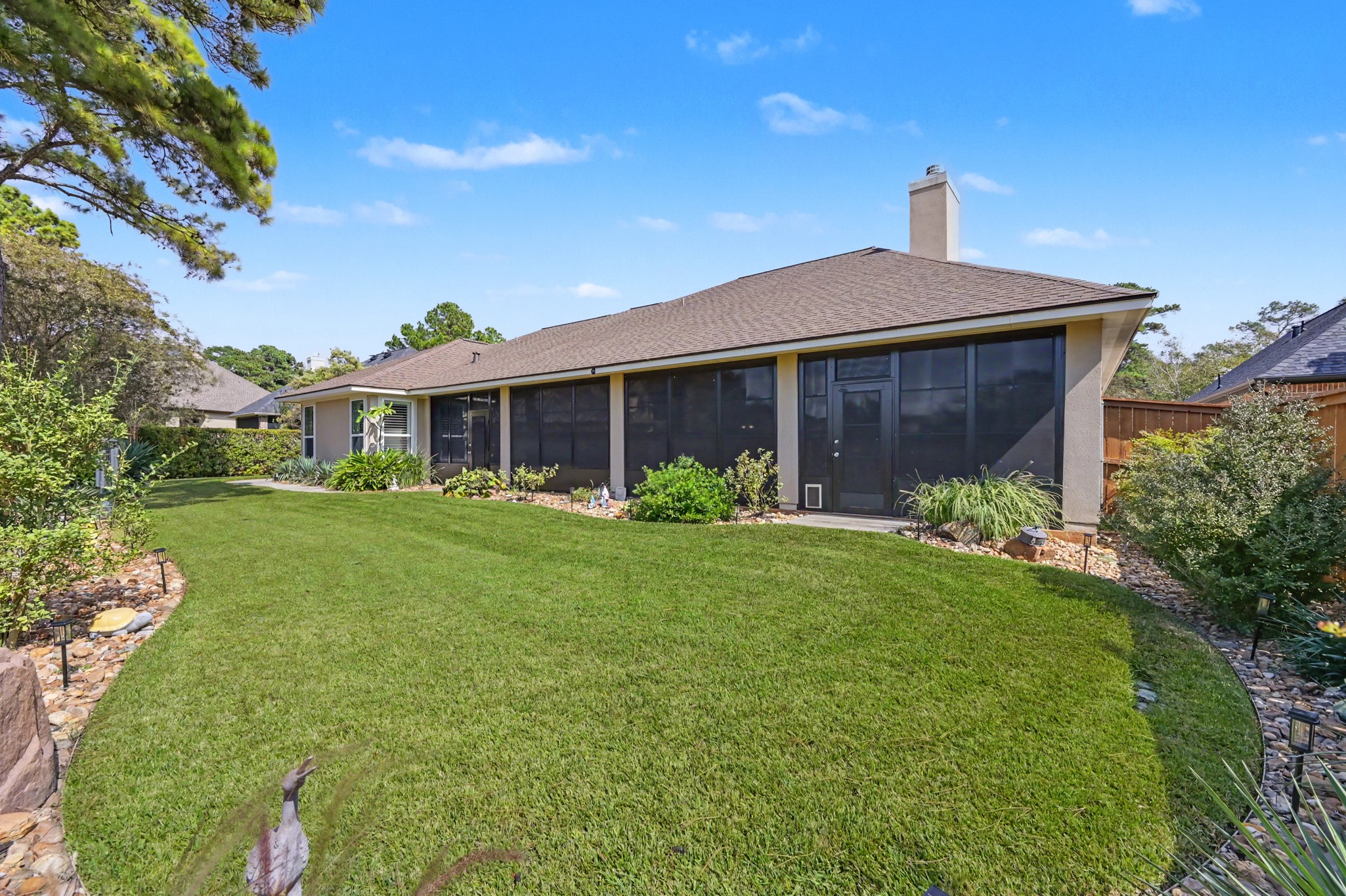 Expansive screened porch overlooking a peaceful, beautifully manicured backyard.