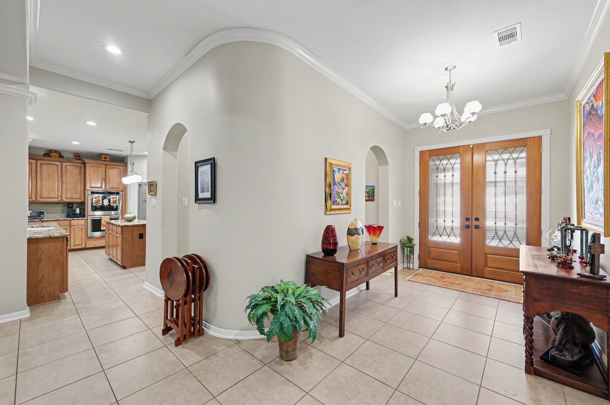 Spacious foyer with graceful architectural details and access to the kitchen and dining areas.