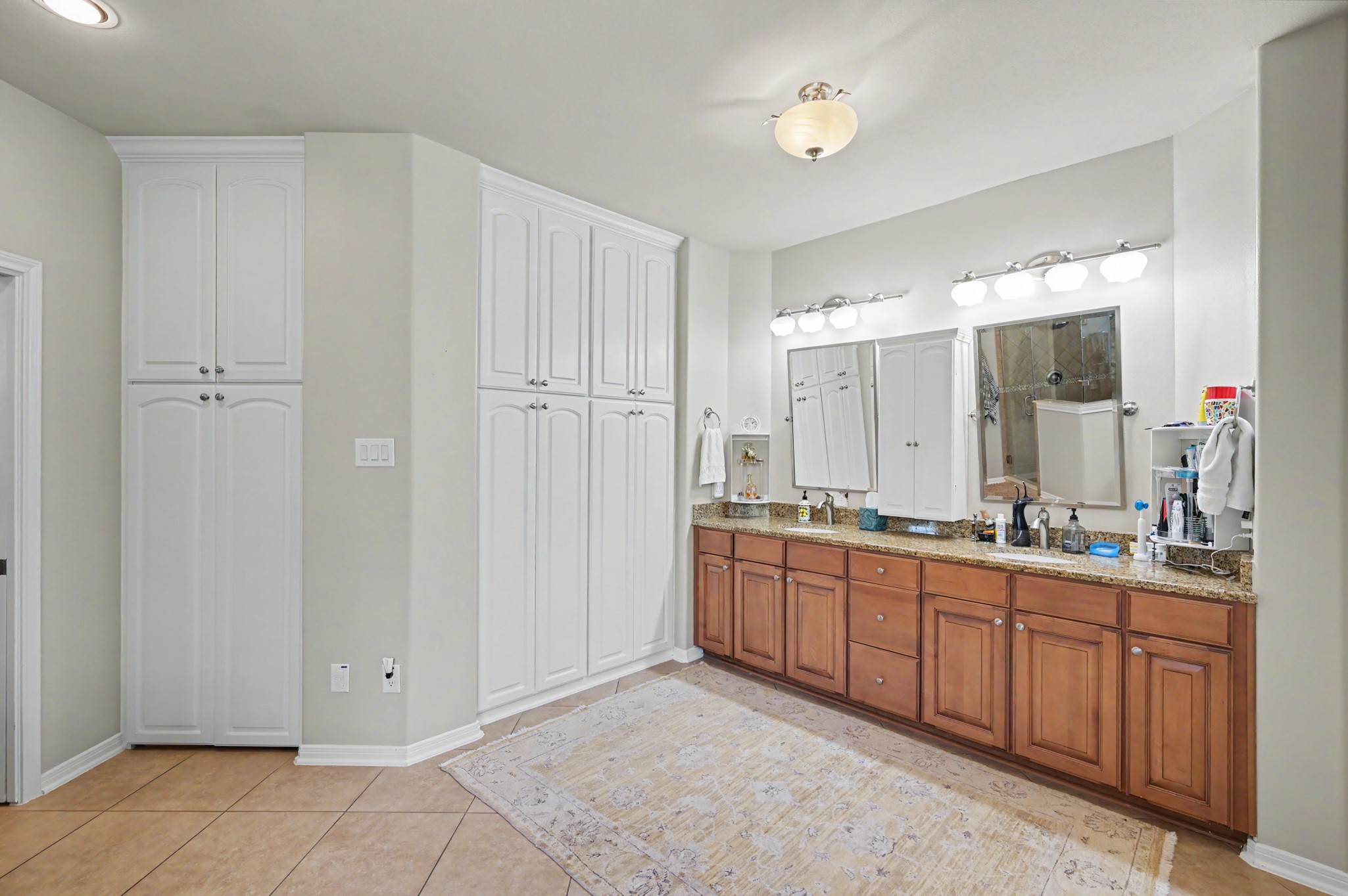 Spacious primary bathroom with dual vanities and extensive built-in storage.