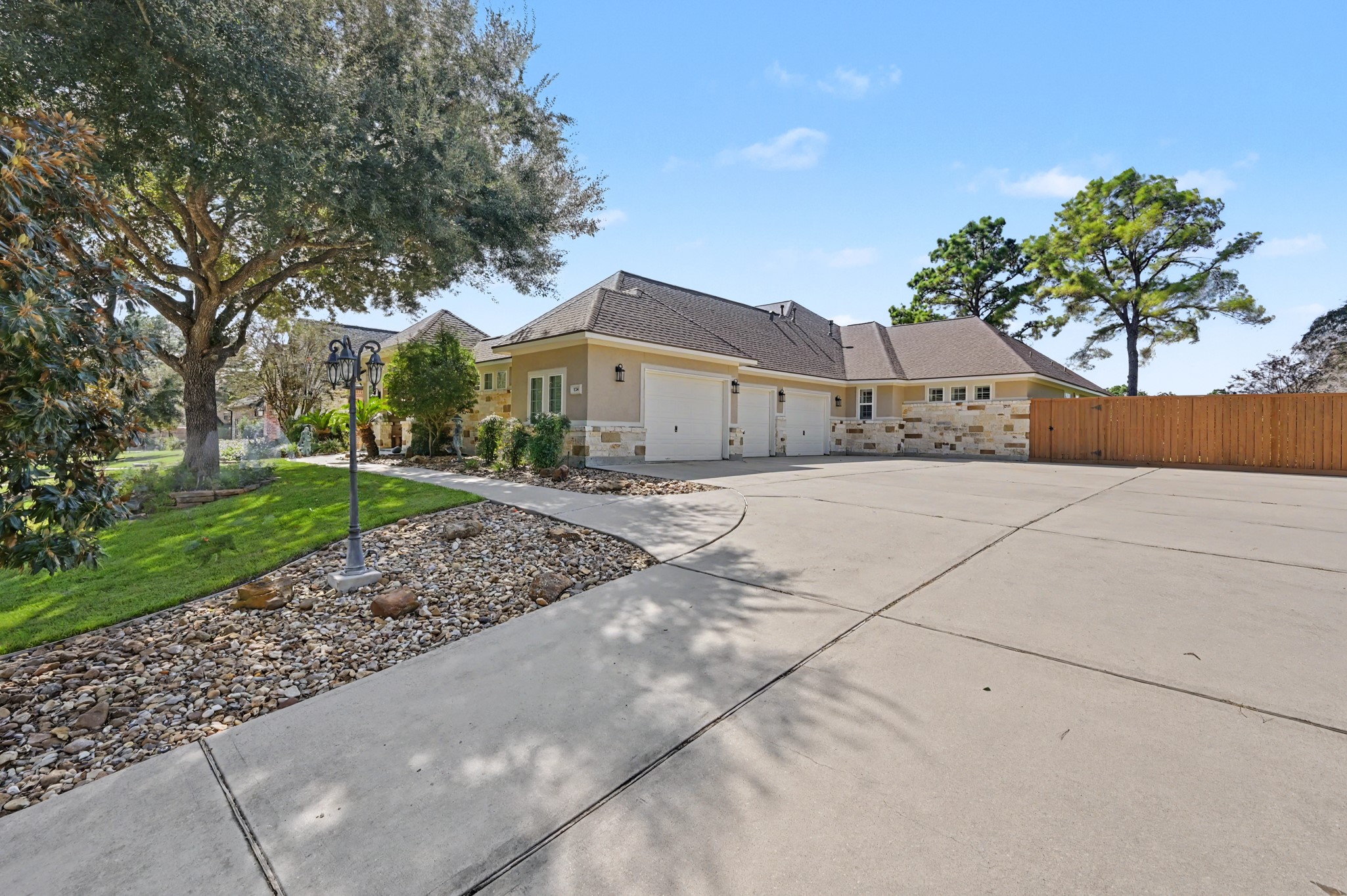 Impressive side-entry garage and generous driveway surrounded by mature trees.
