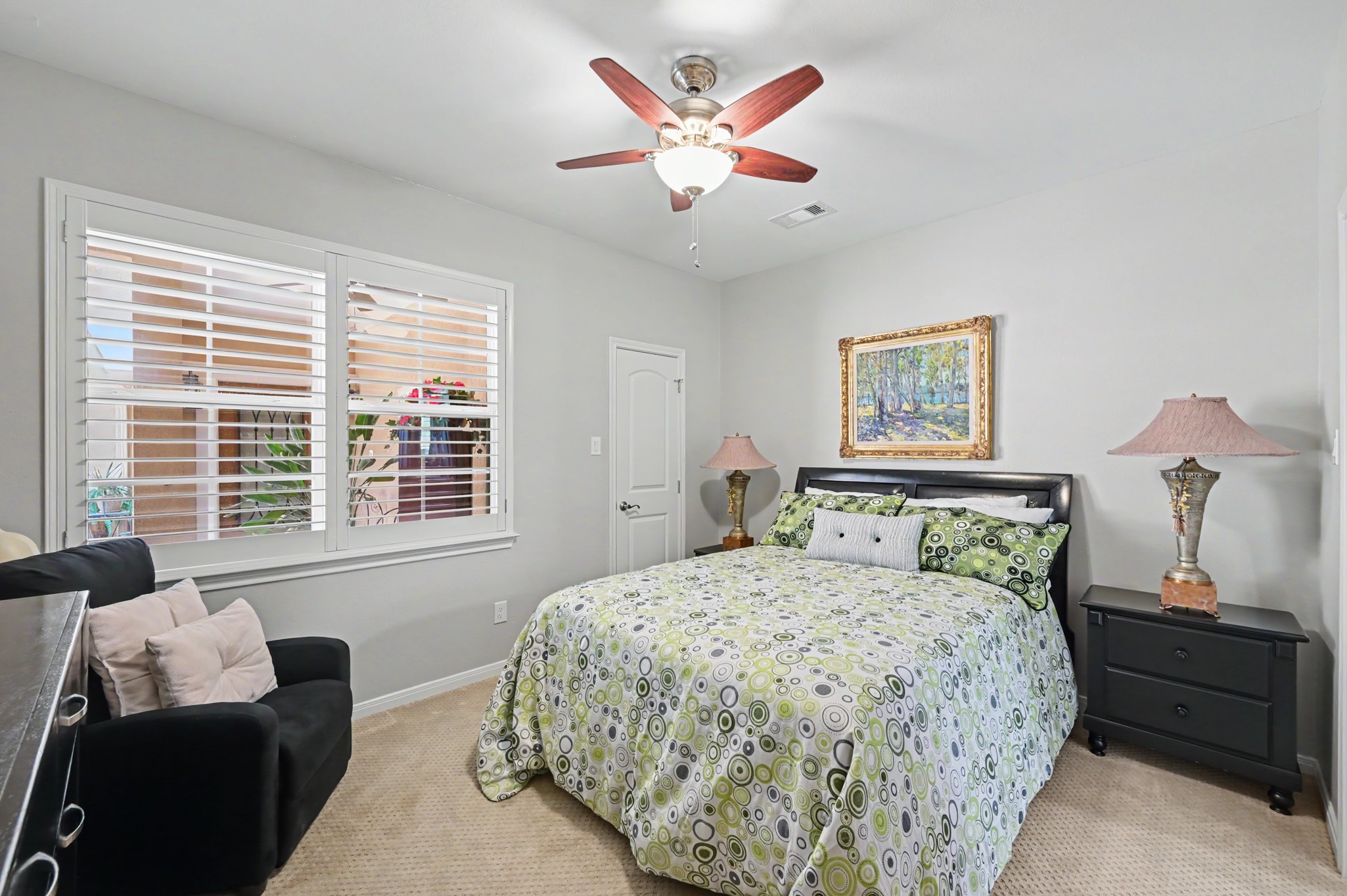Bright, comfortable secondary bedroom with plantation shutters.