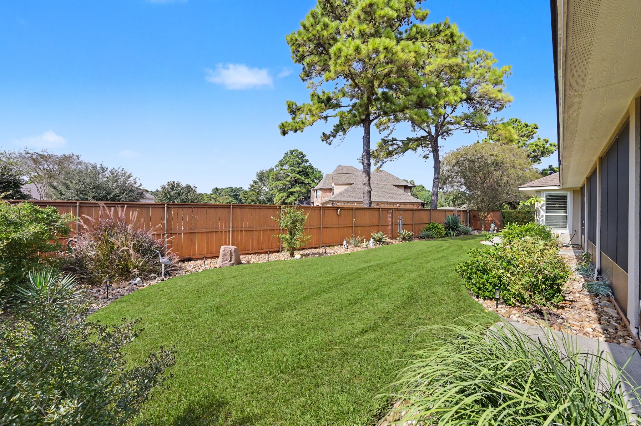 Beautifully maintained backyard with lush green lawn and attractive landscaping.