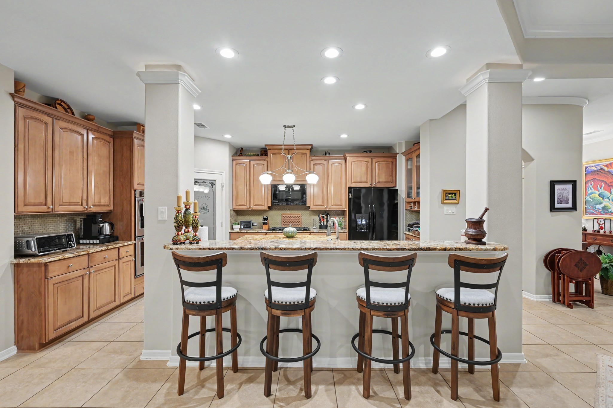 Beautifully designed kitchen with generous breakfast bar seating and rich cabinetry.
