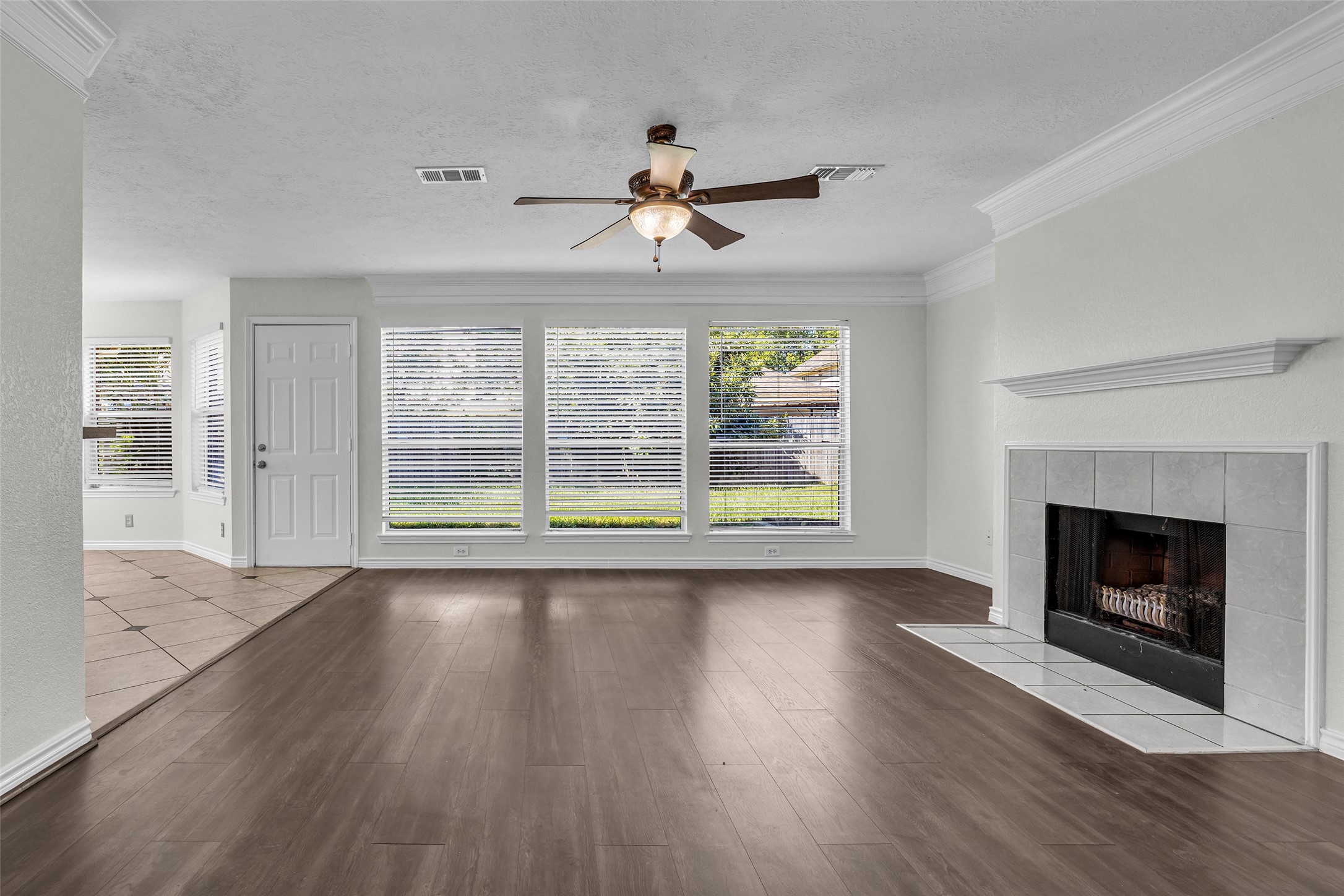 Plenty of natural light and room to spread out, with crown molding and a ceiling fan.