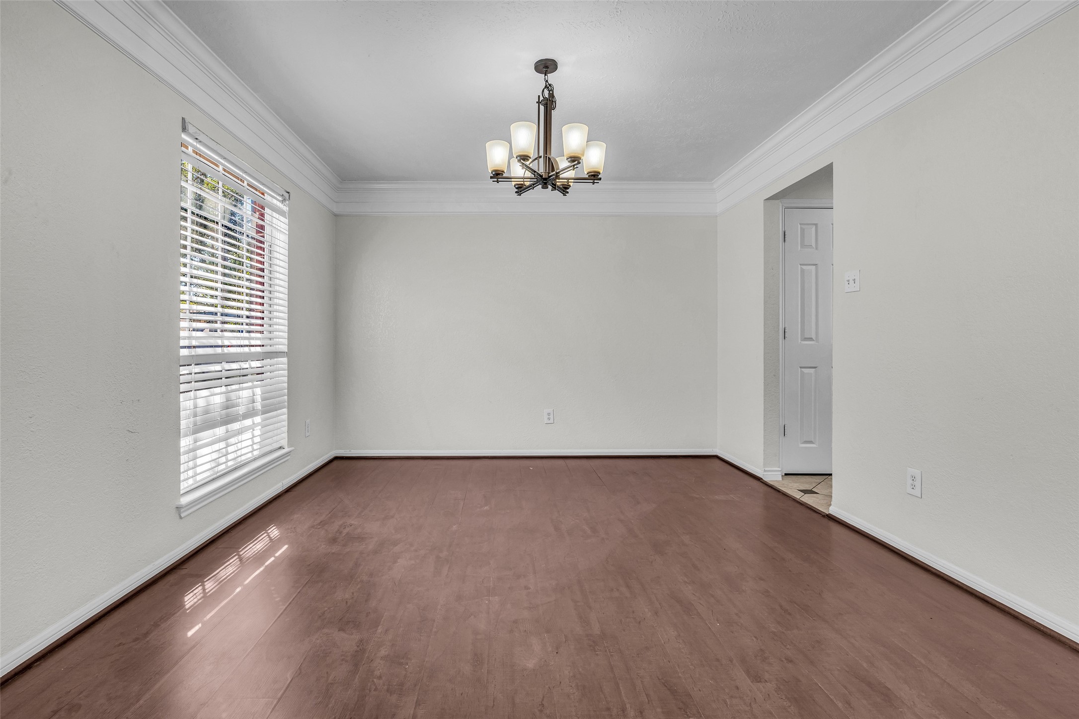 Host holiday dinners in the formal dining room, with crown molding, a chandelier and wood-look flooring. Host holiday dinners in the formal dining room, with crown molding, a chandelier and wood-look flooring.