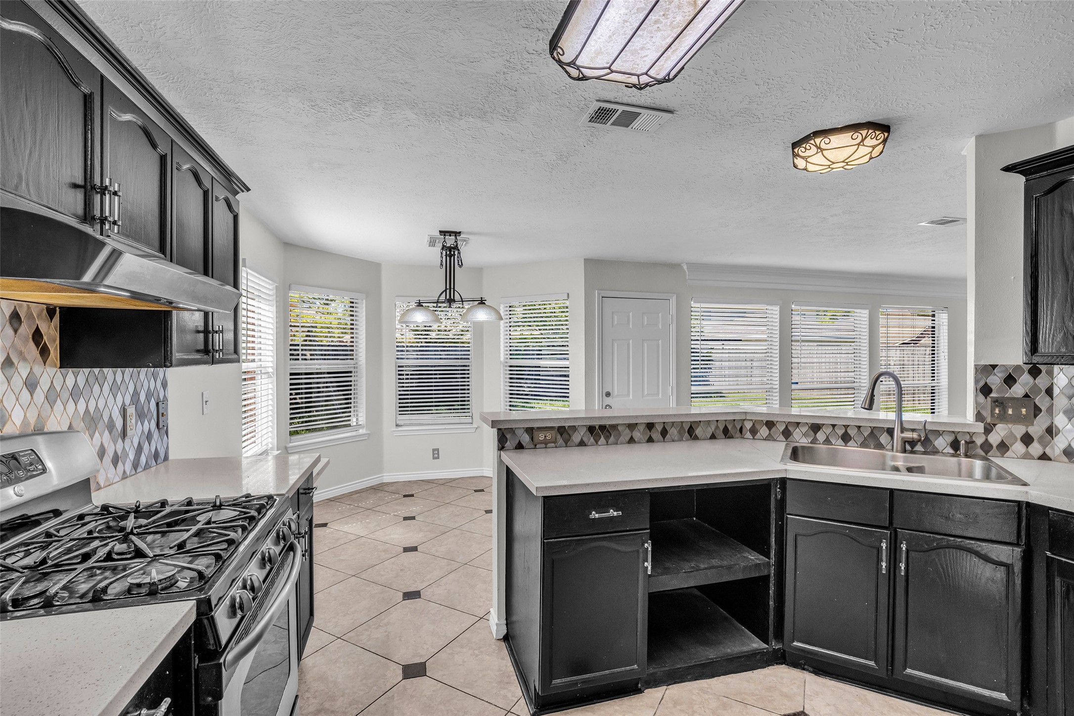 The kitchen opens to a bright breakfast area with bay windows.