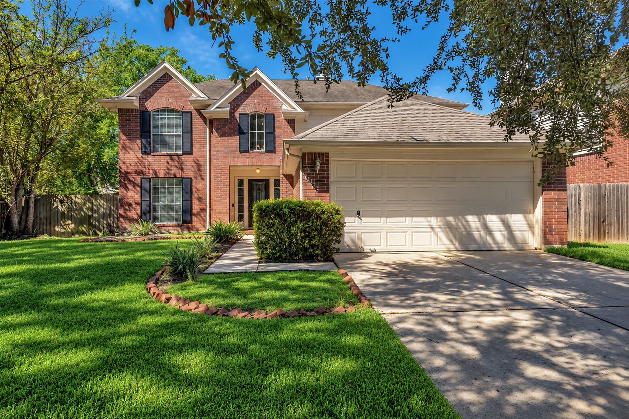 Mature trees and a classic brick facade make for a warm welcome home.