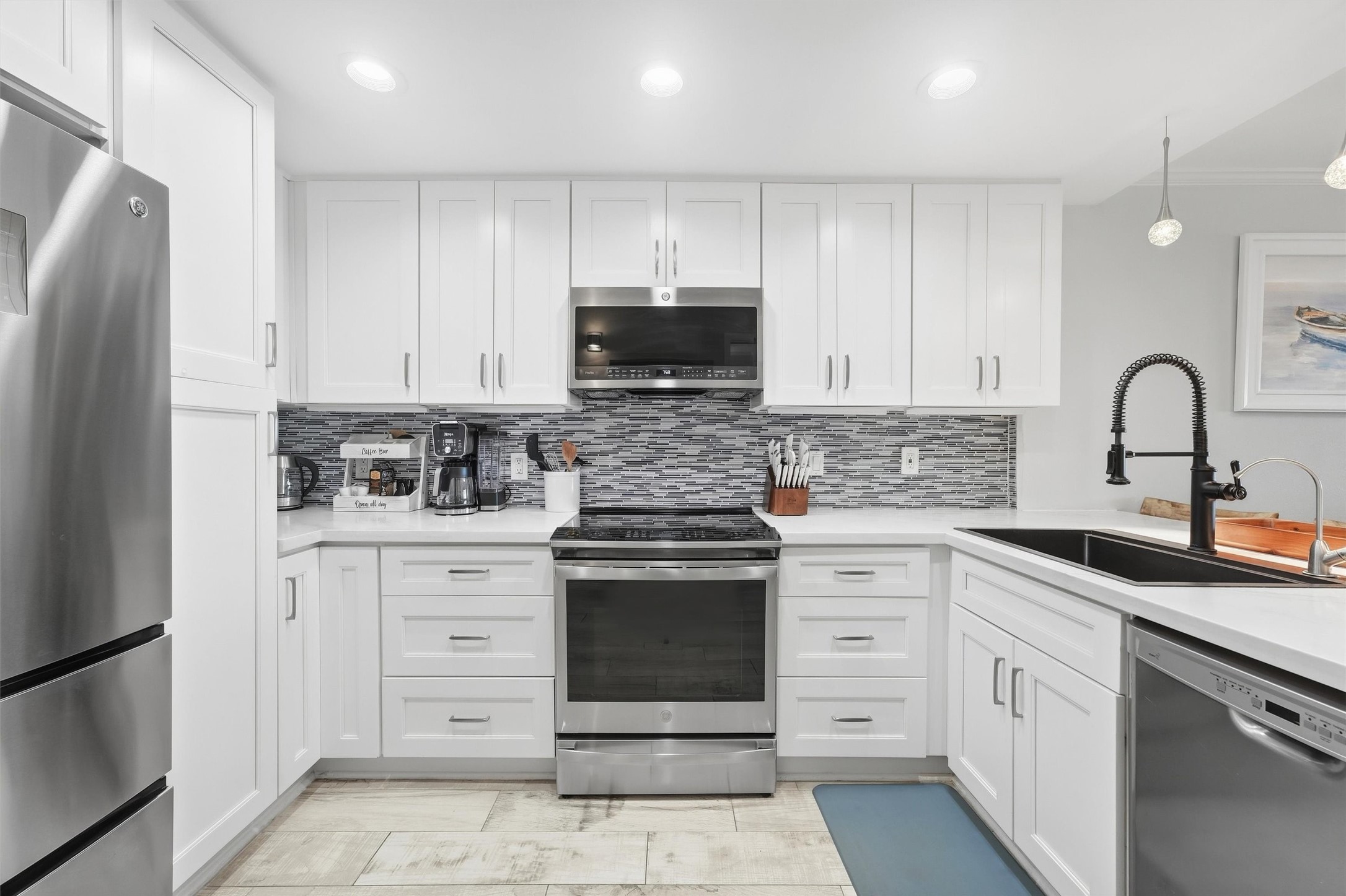 Modern kitchen with sleek stainless steel appliances, white cabinetry, and a stylish tile backsplash. Modern kitchen with sleek stainless steel appliances, white cabinetry, and a stylish tile backsplash.