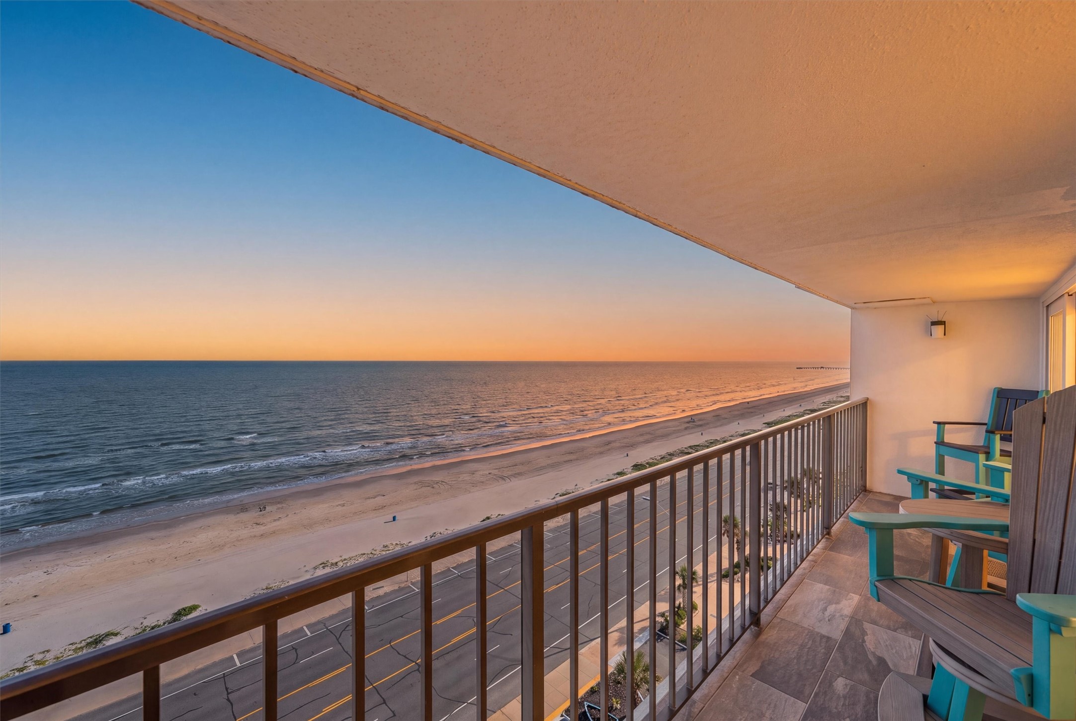 Stunning beachfront balcony offering panoramic ocean views, perfect for enjoying serene sunsets and the soothing sound of waves.