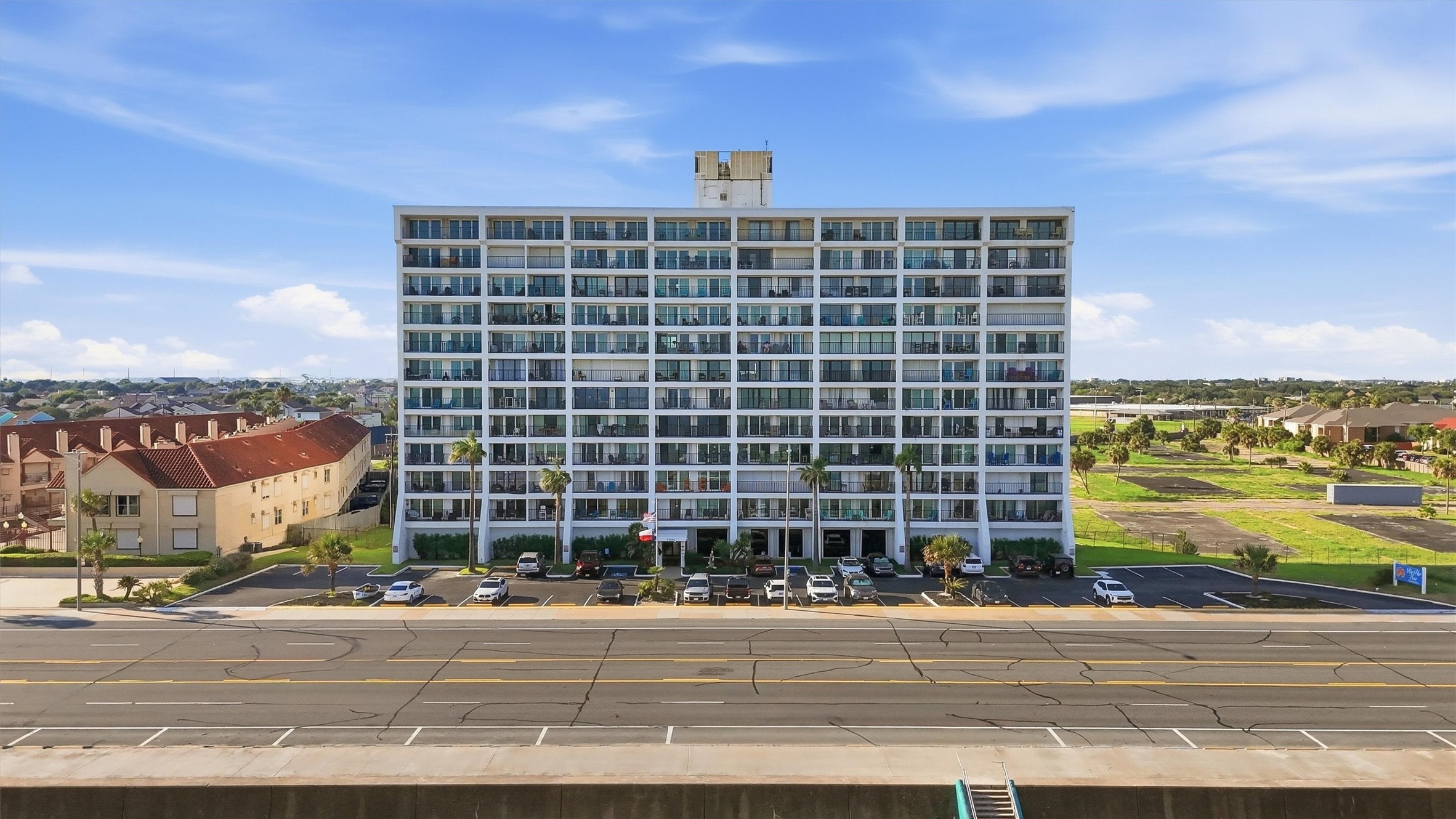 Modern high-rise building with ample parking, offering convenient urban living and expansive views.