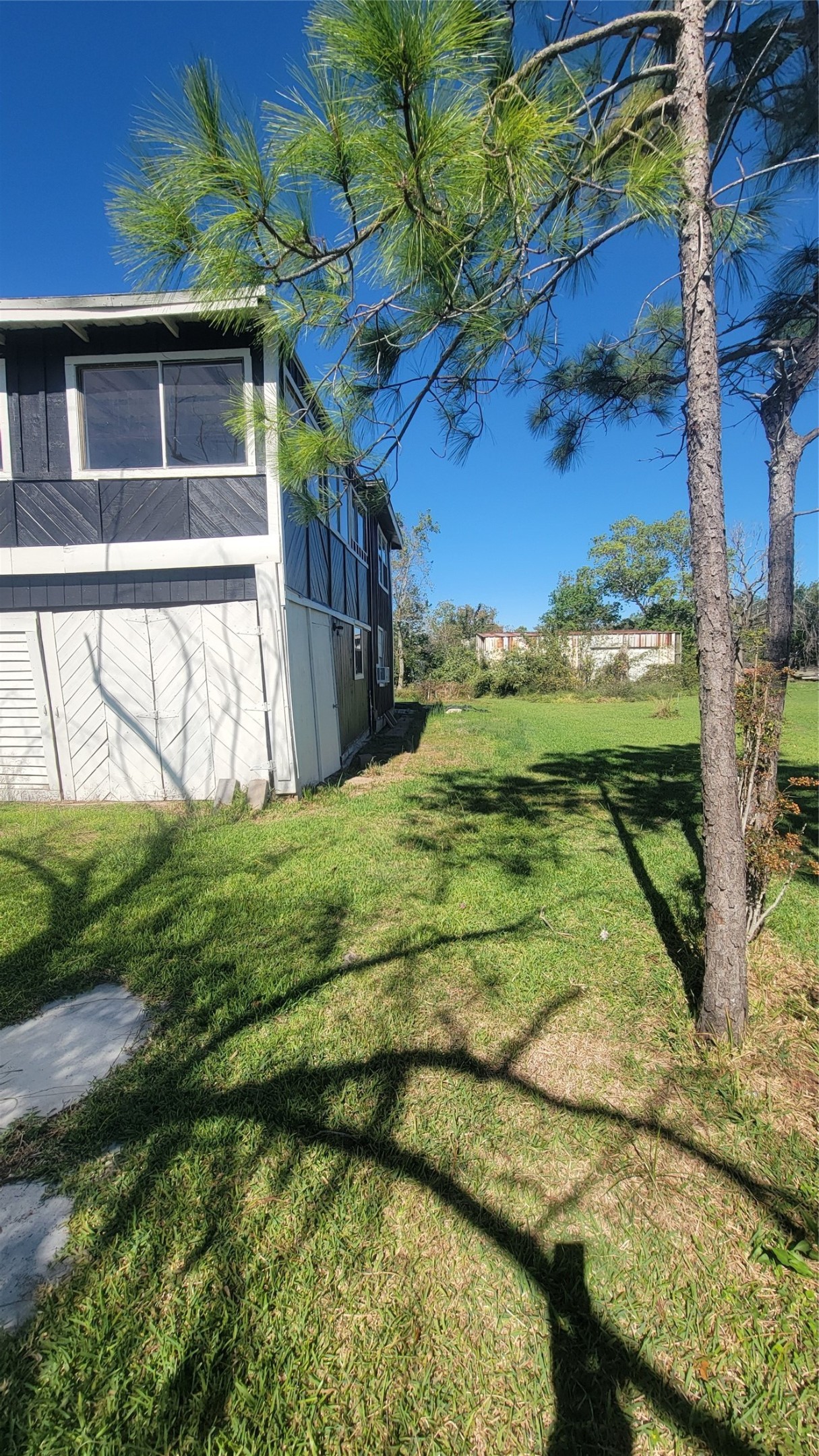 Charming two-story home with a spacious grassy yard, surrounded by trees, offering privacy and a serene outdoor space. Ideal for enjoying nature and outdoor activities.