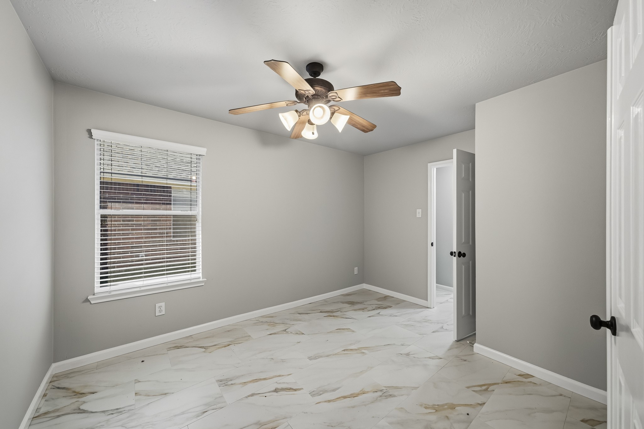 Private home office featuring sleek tile flooring and elegant double doors for added privacy. The room includes a ceiling fan for year-round comfort and offers a convenient layout that connects directly to the primary bedroom suite.