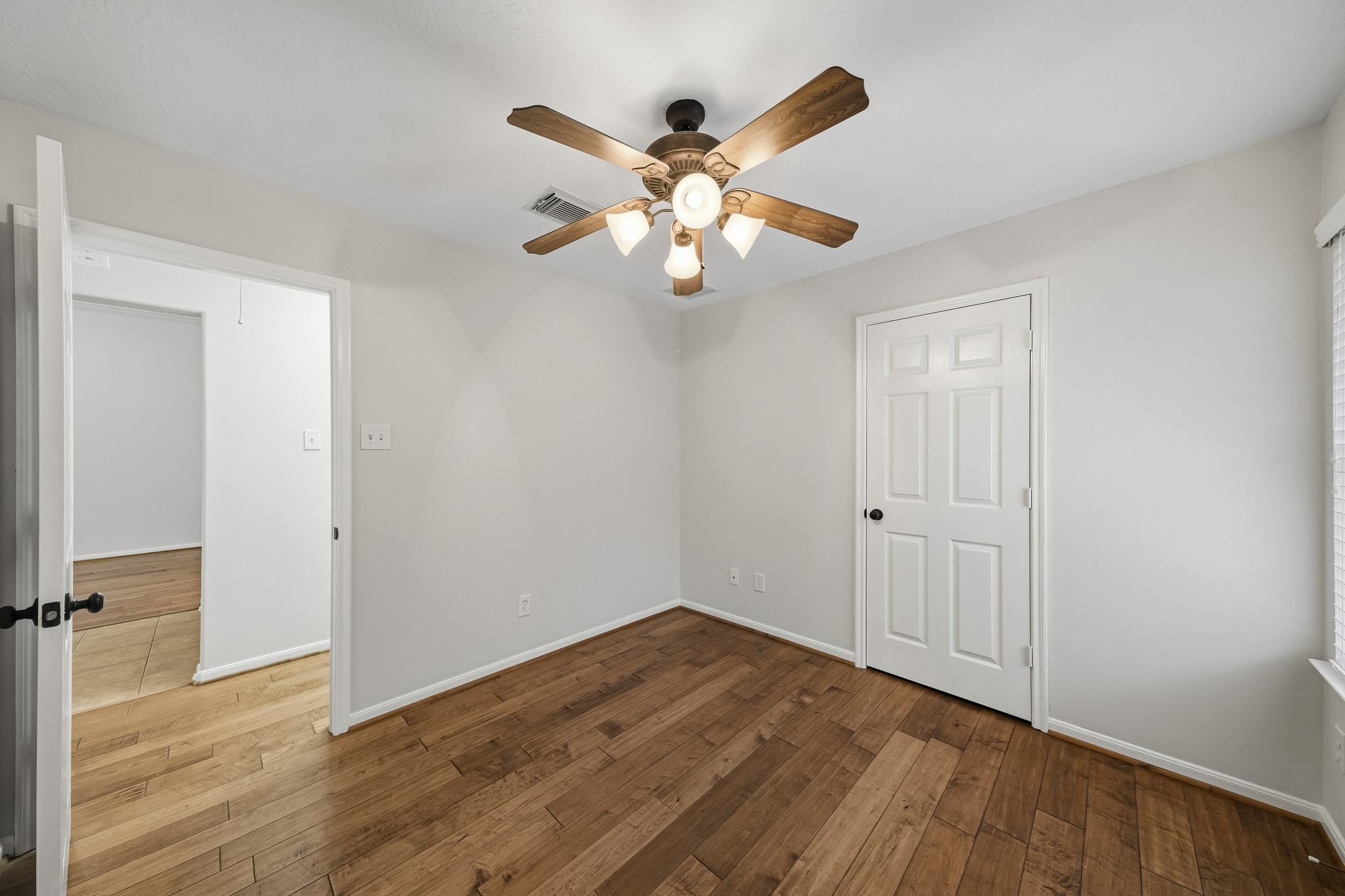 Secondary bedroom featuring a spacious walk-in closet, ceiling fan for comfort, and abundant natural light.