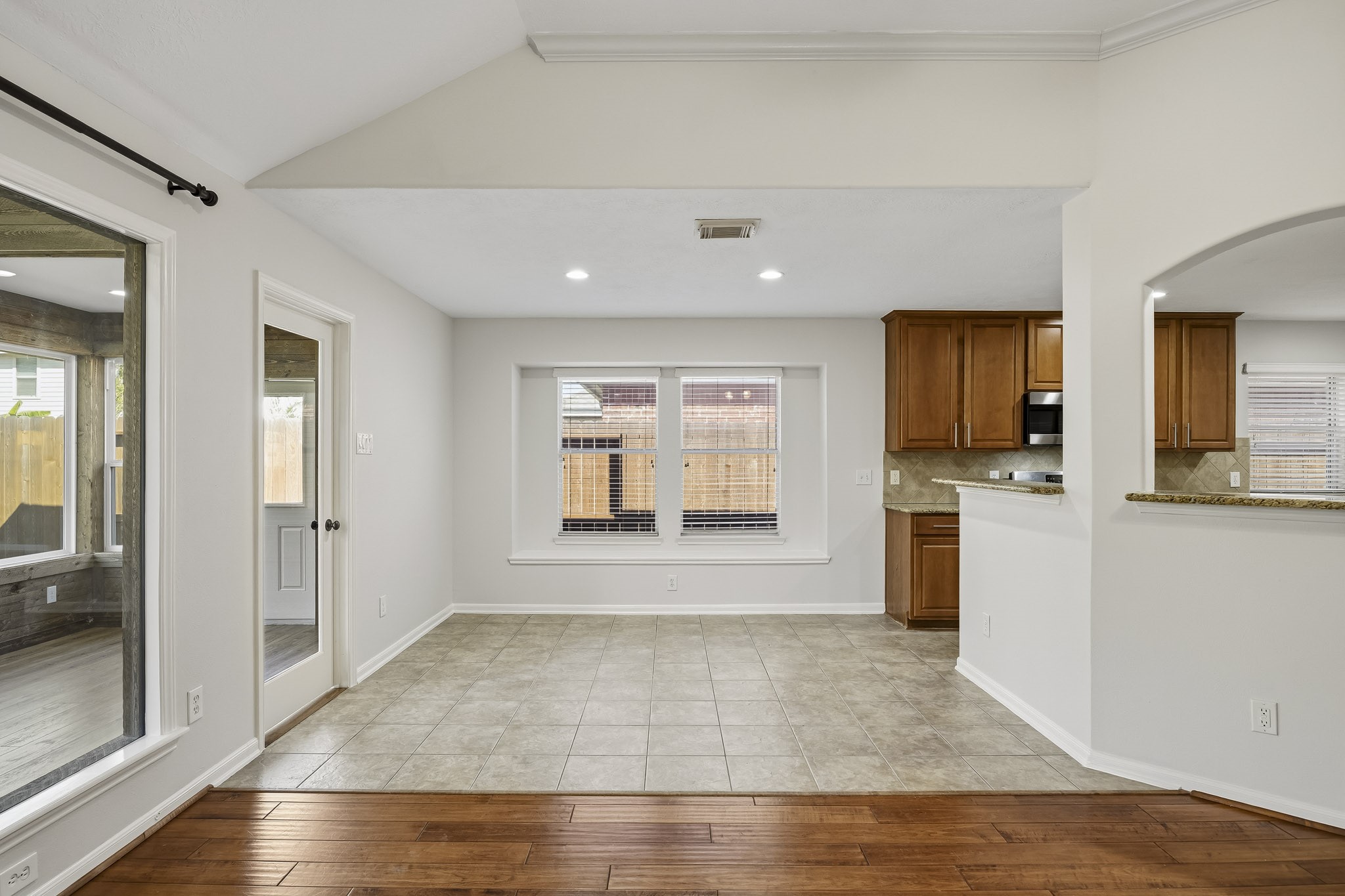 Breakfast area featuring an abundance of natural light, durable tile flooring, and a seamless open-concept design that flows into the kitchen and living spaces.