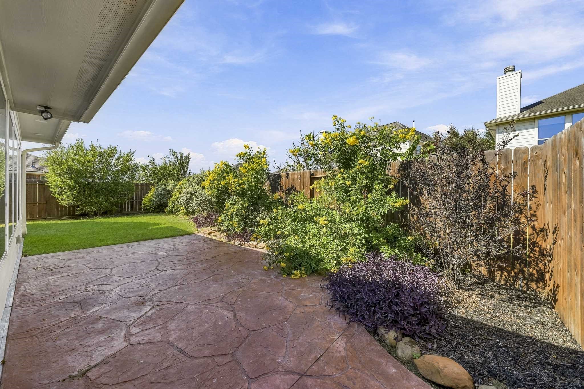 Experience the tranquility of a beautifully maintained, lush landscape that perfectly frames this inviting patio space, offering a serene retreat right at home.