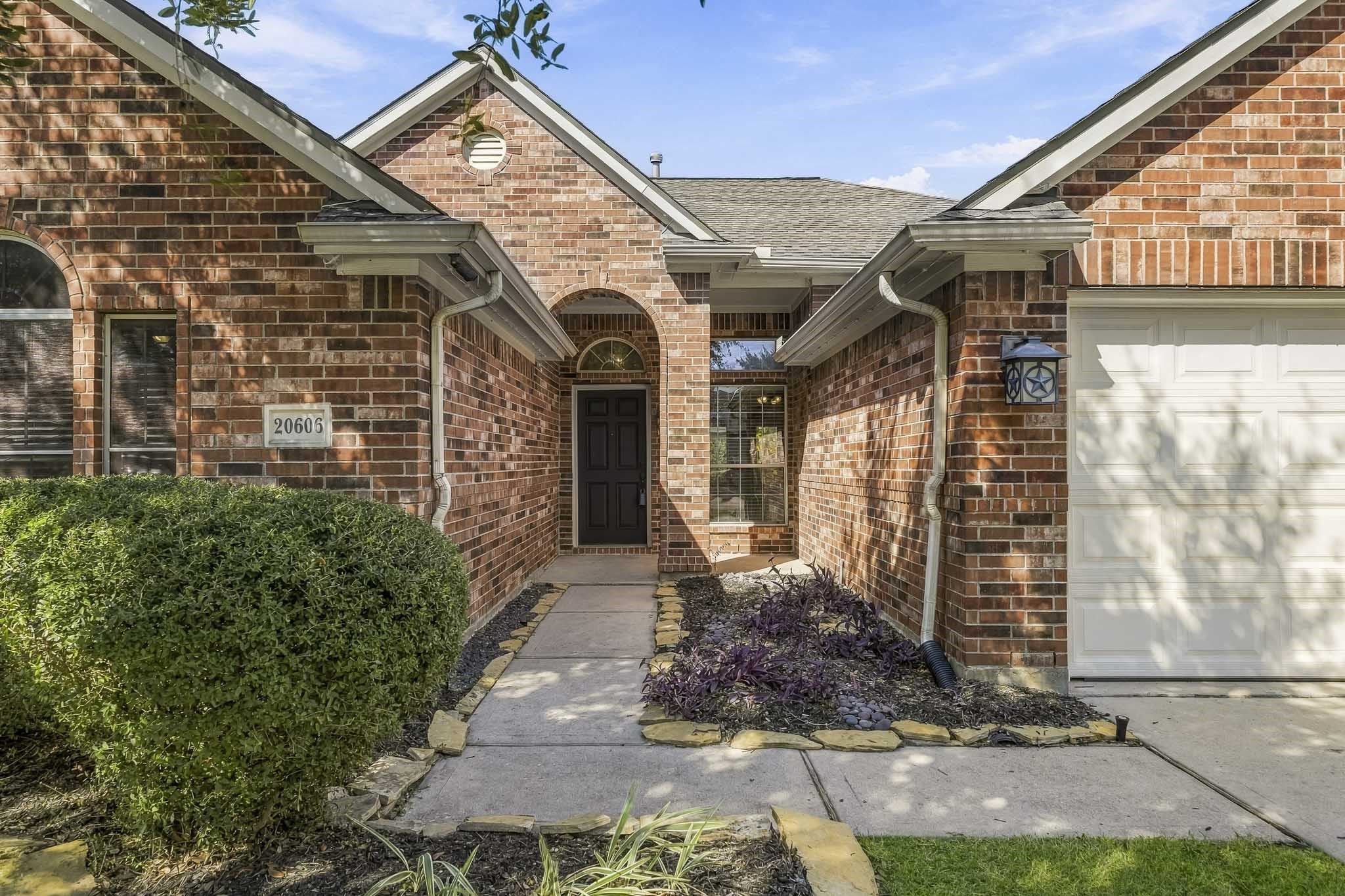 Lovely one-story brick home featuring a welcoming entry framed by established, lush landscaping. Lovely one-story brick home featuring a welcoming entry framed by established, lush landscaping.