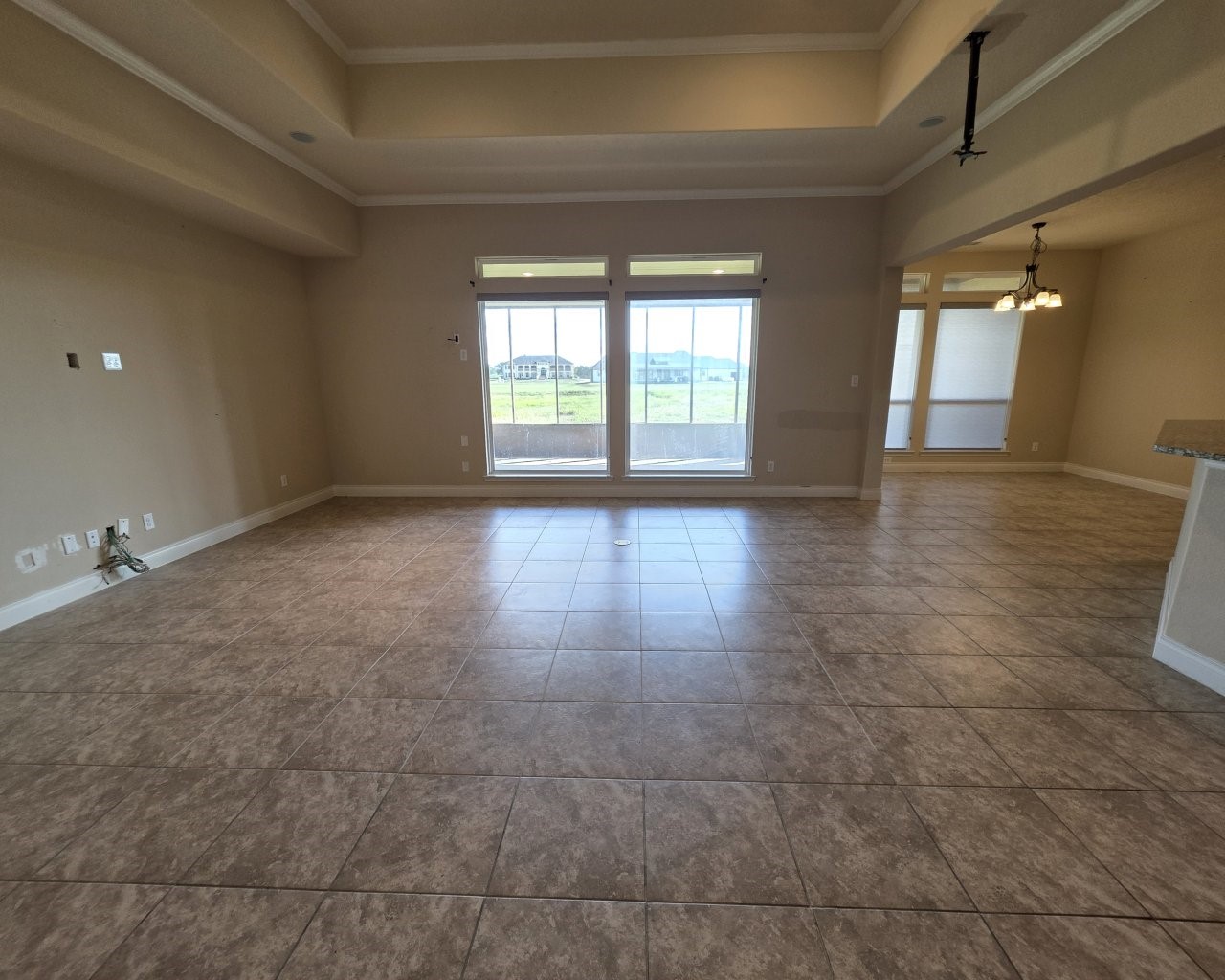 Spacious living room with tile flooring and a alcove ceiling