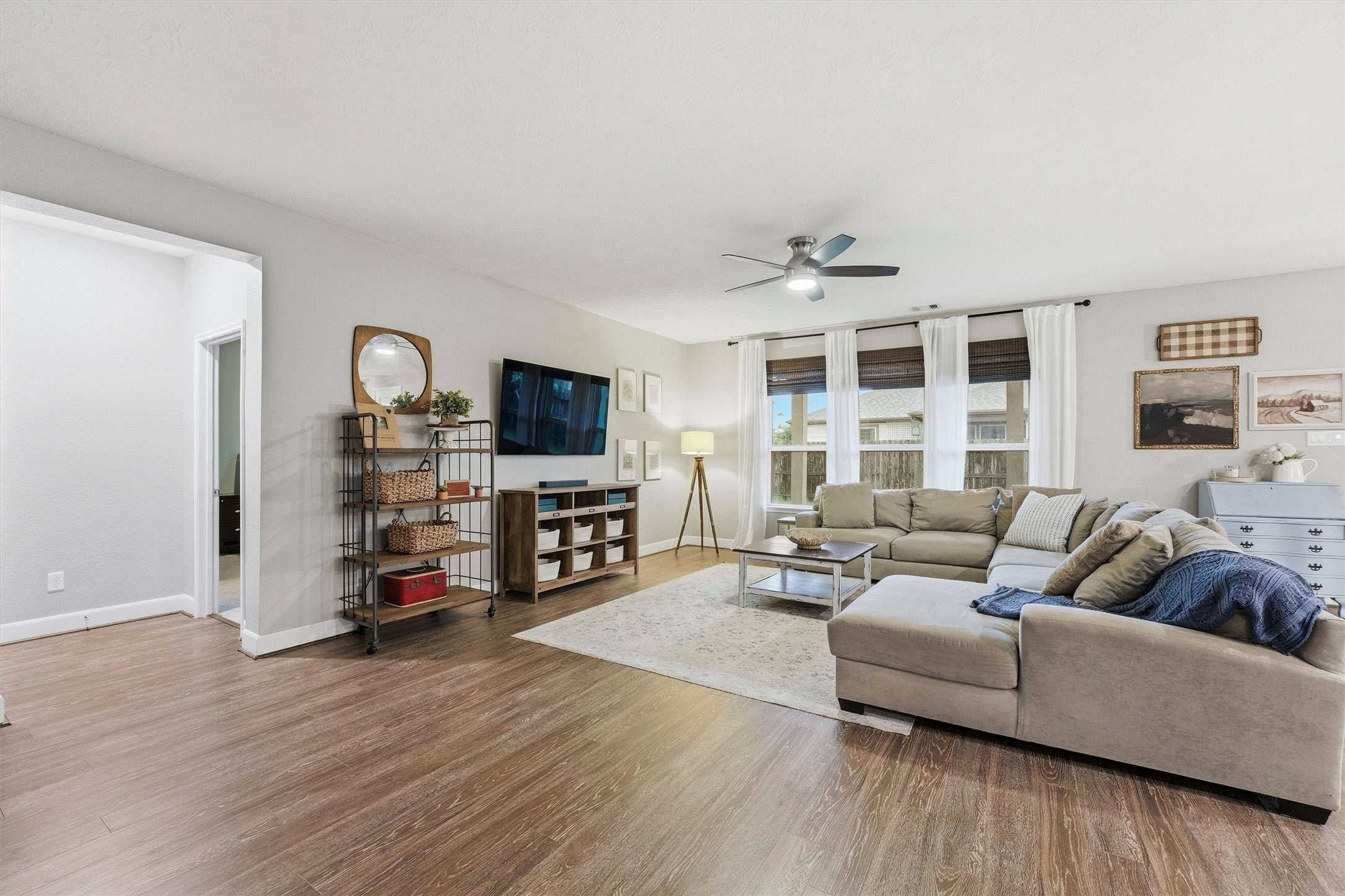 This spacious living room features abundant natural light, wood-look LVP flooring, and an open concept layout perfect for entertaining.
