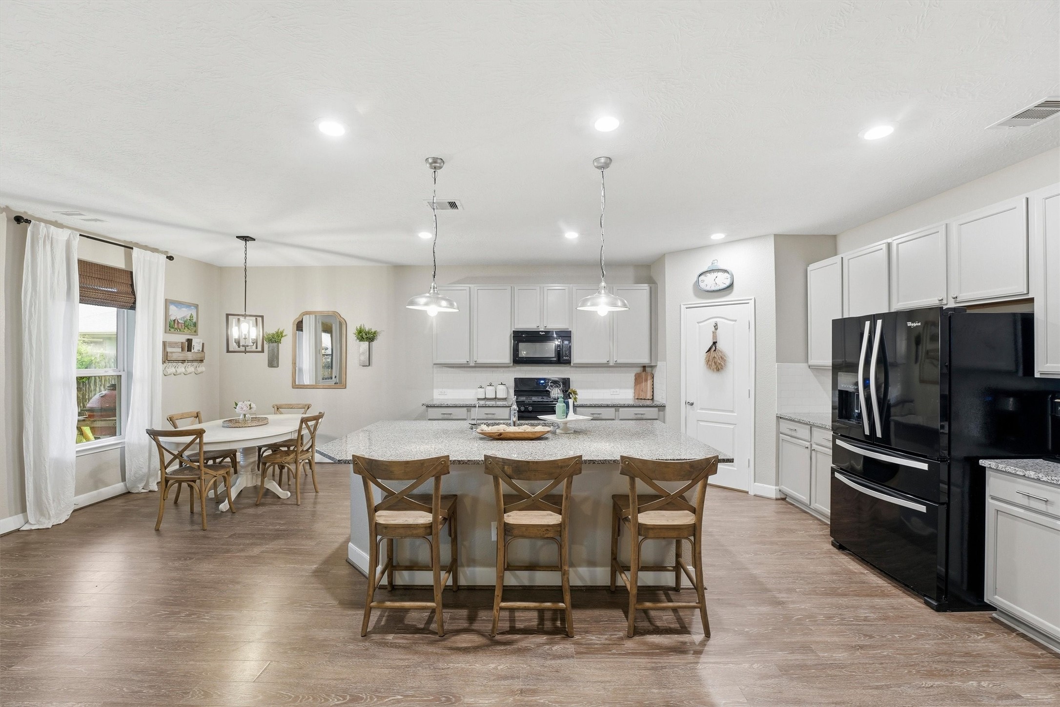 Large kitchen with spacious center island (truly- it's huge!) with bar seating, abundant cabinetry, and an adjacent dining area.
