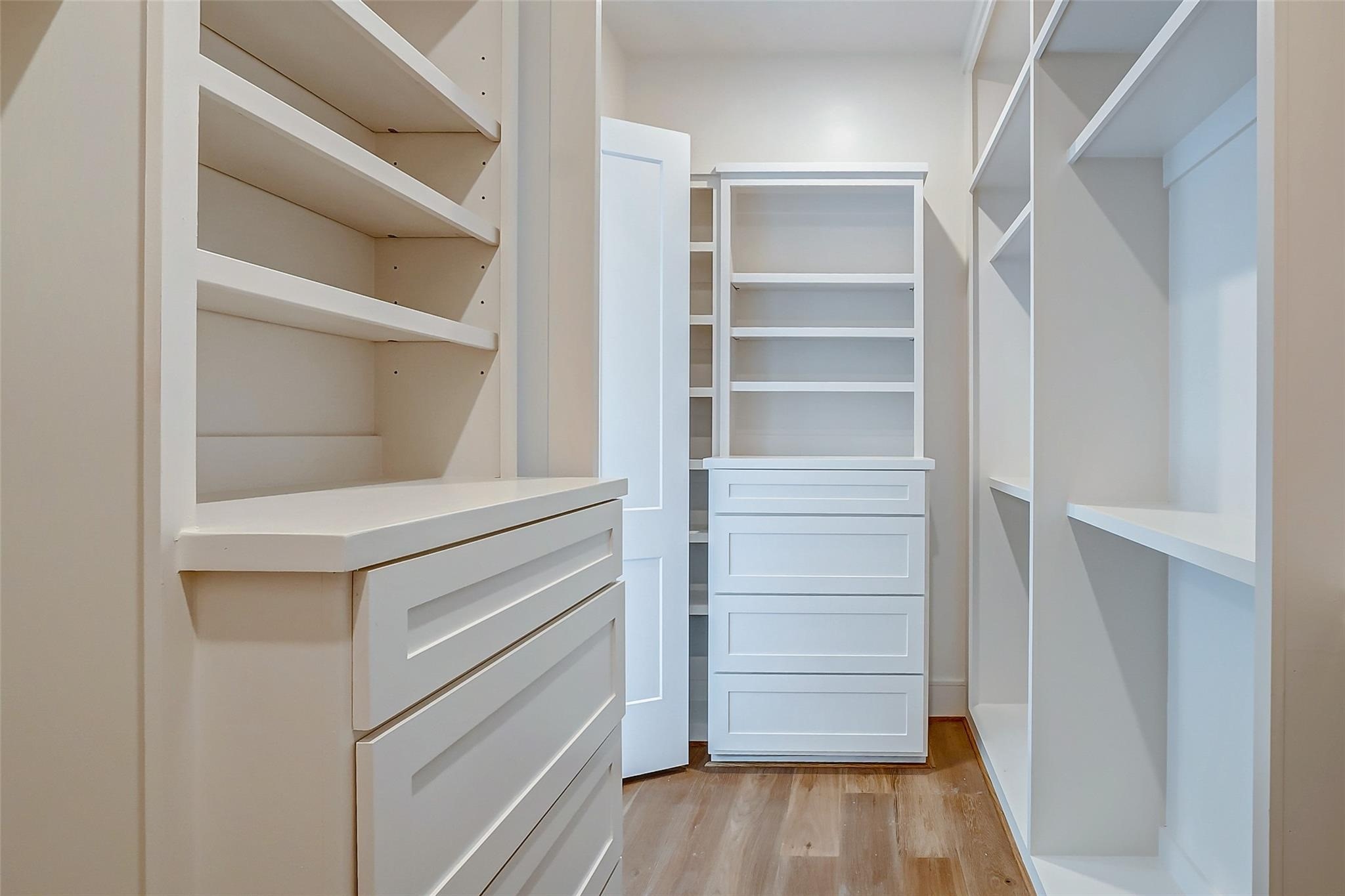 Grand walk in closet with custom built-ins and plenty of storage space for any wardrobe.