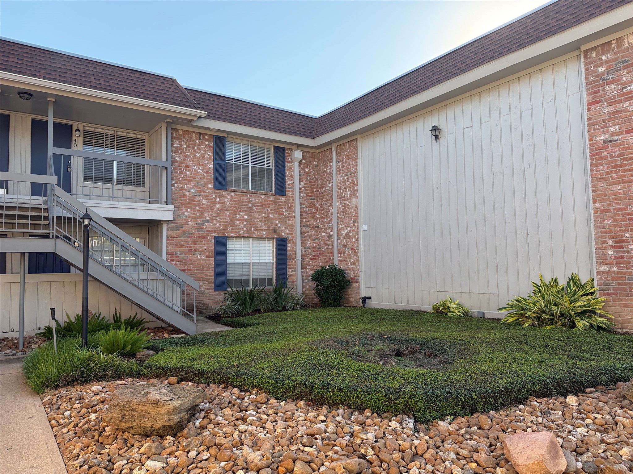 Covered second-floor balcony overlooking the landscaped courtyard, offering a welcoming outdoor space.