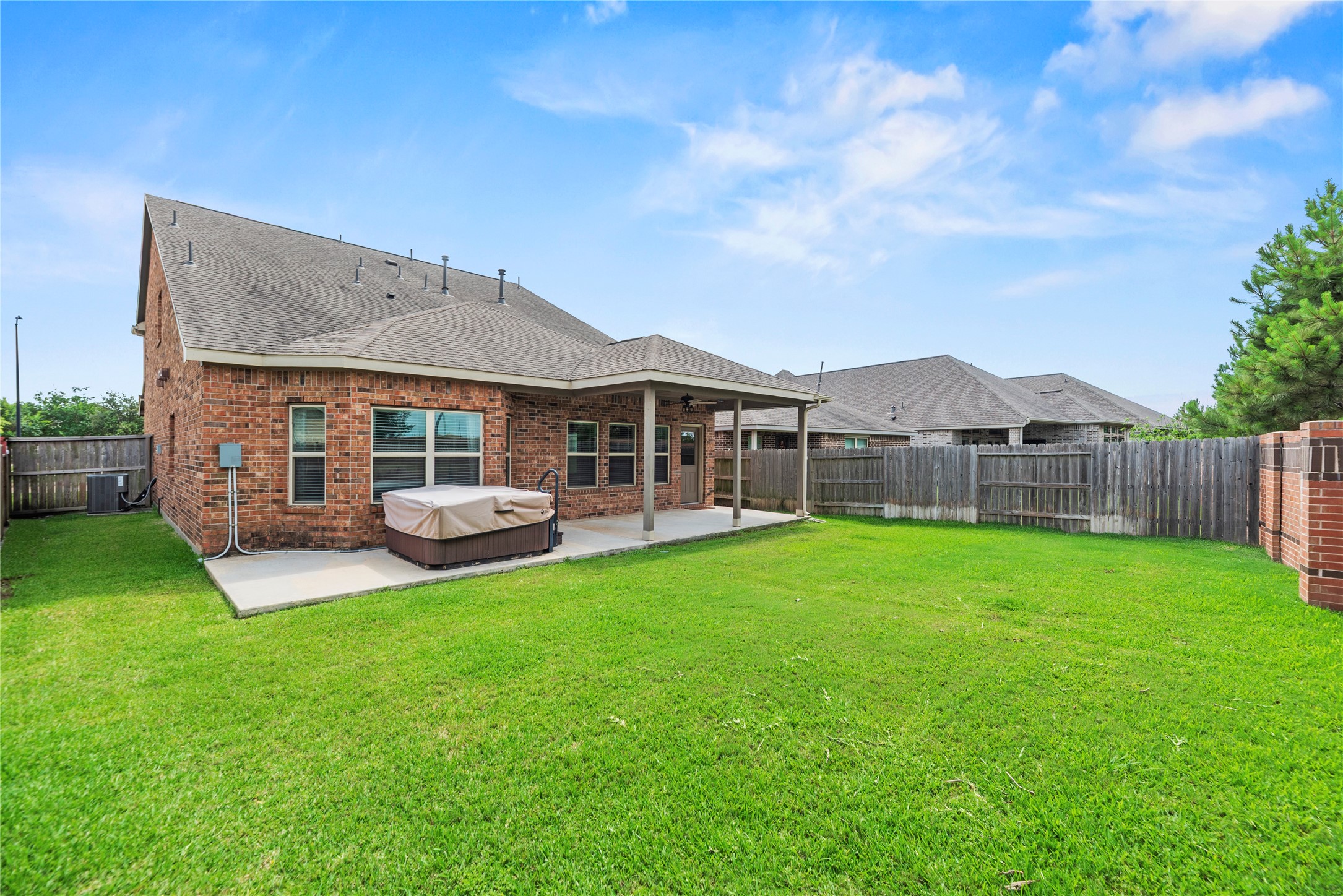 Another perspective of the backyard shows off the sprawling lawn and wrap-around green space, offering an open layout that easily accommodates future playground sets or gardening projects.