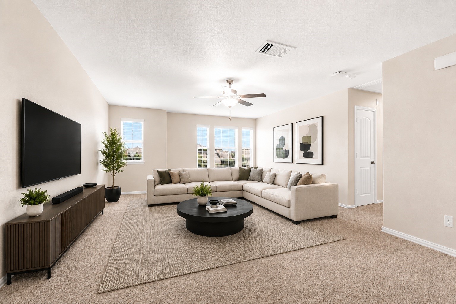 The upstairs gameroom functions as an ideal second living area, media center, or play zone. This room is finished with plush carpeting, neutral wall colors, a central ceiling fan, and multi-window views of the community.  Virtually staged.