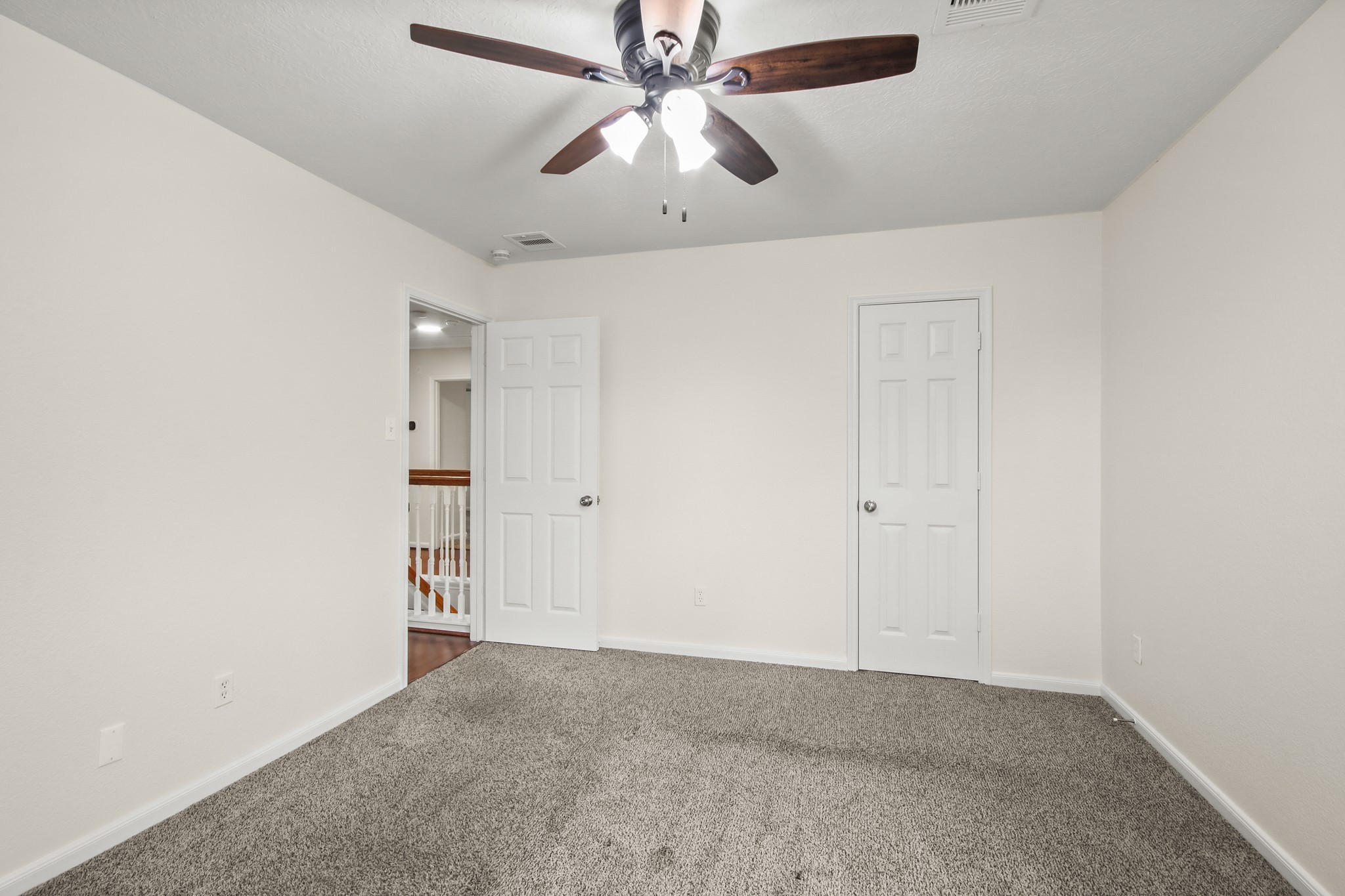Another view of the bedroom showcases how spacious it is. It is complete with a built-in closet.