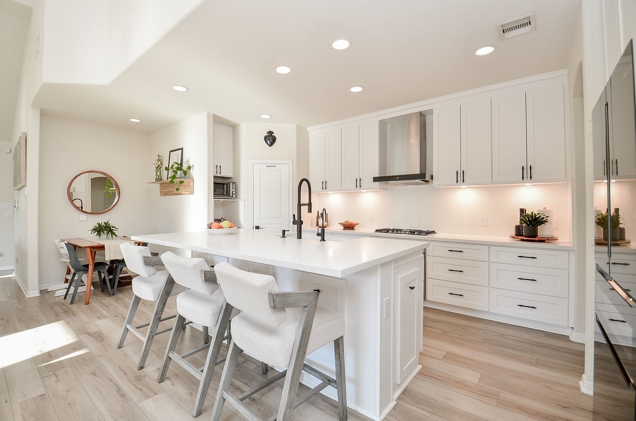 Stunning renovated kitchen with white cabinetry, oversized island, and sleek finishes.